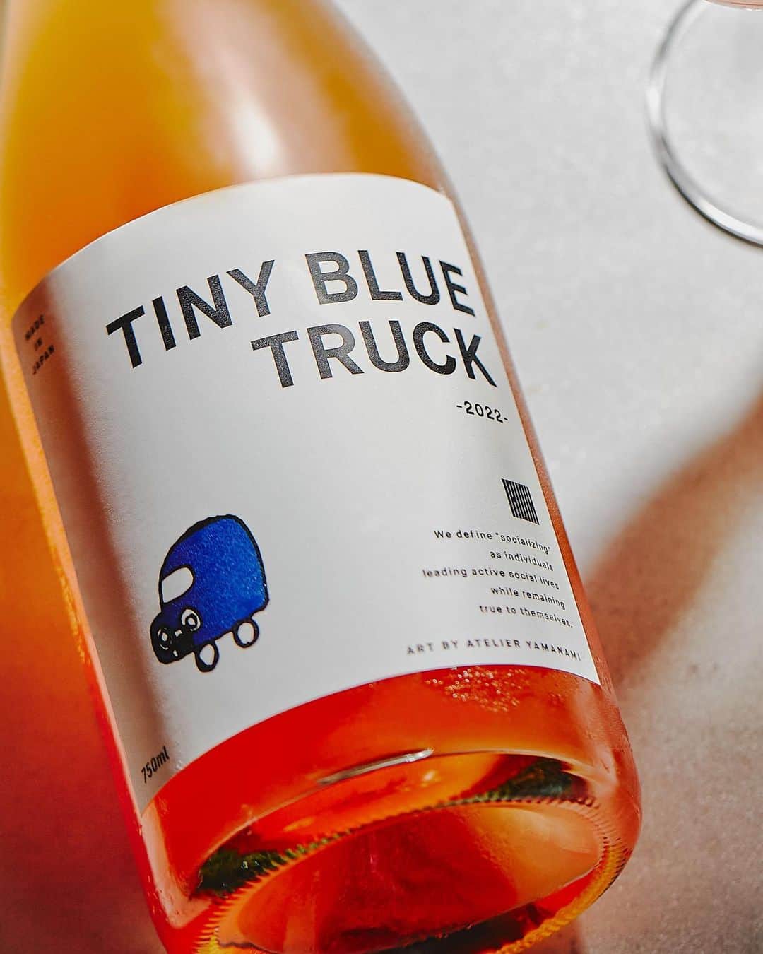 TRUNK(HOTEL)のインスタグラム：「●TINY BLUE TRUCK 2022 TRUNK(HOTEL) Limited Edition  "TINY BLUE TRUCK 2022(青い軽トラ2022) TRUNK(HOTEL) Limited Edition” 第3弾はオリジナルラベルのロゼワイン。 薄濁りのアプリコット色の微発泡で、開けたては瑞々しい香りと吟醸香。  過疎化に苦しむ地元広島県の支援や、障害者の社会参加に積極的に取り組んだこのプロジェクトと、TRUNK(HOTEL)が掲げる等身大の社会貢献SOCIALIZINGが深く共鳴し合い、2020年の初のコラボレーションボトルからシリーズ化しました。  このワインの売り上げの一部は、no.501を通して、障害者支援施設をはじめ、過疎化する地元地域の支援金として寄付いたします。  9月1日から300本限定で、TRUNK(LOUNGE)、TRUNK(KITCHEN)、TRUNK(STORE)での提供を開始し、TRUNK(STORE)では、ラベルデザインに使用したイラストの原画を展示しております。  TRUNK(STORE)オンラインストアへは、プロフィールのURLからアクセスできます。  ・・・  "TINY BLUE TRUCK 2022 TRUNK(HOTEL) Limited Edition" The third edition is a rosé wine with an original label.  It has a slightly cloudy apricot-colored foam, and upon opening it, you are drawn in by a fresh and fruity aroma.  This project was actively engaged in supporting the local Hiroshima Prefecture suffering from depopulation and public participation of disabled communities. TRUNK(HOTEL)'s life-size social contribution “SOCIALIZING” resonated deeply with each other and the series began with the first collaboration bottle in 2020.  A portion of the proceeds from the sale of this wine will be donated through No.501 in hopes to support facilities for the disabled and other depopulated local communities.  Limited to just 300 bottles from September 1st, “TINY BLUE TRUCK” will be available at TRUNK(LOUNGE), TRUNK(KITCHEN), and TRUNK(STORE). The bottle label’s original handmade design can also be found at the TRUNK(STORE).  TRUNK(STORE) can be accessed online through the URL in the profile.  #trunk #trunkhotel #trunkkushi #socializing #hotel #tokyo #jingumae #harajuku #wine #roséwine」