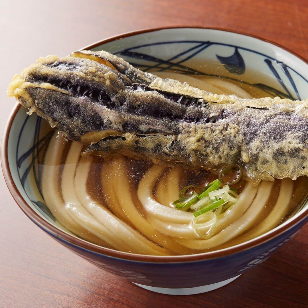 丸亀製麺のインスタグラム：「食べてみたい期間限定天ぷらをコメントで教えてください👀  今月も旬の味わいが楽しめる季節限定天ぷらが登場！ ラインナップはこちら👇  🥢そのままサクッ、だしにつけてジュワッと味わいたい #長なす天 🥢柔らかくふわっとした身が特徴！だししょうゆで食べたい #太刀魚天 🥢じゃがいもの甘みがだしに溶け込む #コロッケ  🥢ほんのりとした甘味とぱつっとした食感が特徴 #万願寺とうがらし天   この機会にぜひお試しください😋  ※一部取扱のない店舗がございます。 ※長なす天は北海道・東北は取扱がございません。 ※万願寺とうがらし天は北海道・東北は9月10日ごろまでの販売となります。  #丸亀製麺 #丸亀うどん #udon #麺 #うどん #天ぷら」