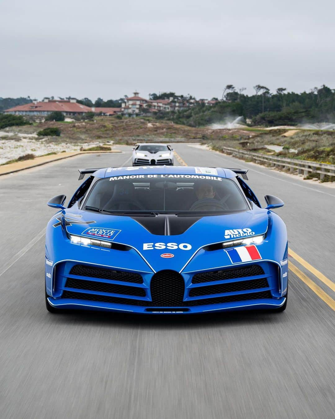 ブガッティのインスタグラム：「One magical BUGATTI moment. Two contrasting but equally compelling CENTODIECI masterpieces on a 17-Mile Drive tour.  The two CENTODIECI models – a beautiful homage to the legendary EB110 heritage – cruise from Pebble Beach and Pacific Grove into the Monterey Peninsula.   Only 10 CENTODIECI examples have been built, making this gathering a rare but enchanting moment.  #BUGATTI #CENTODIECI #BUGATTIGreenwich  – WLTP: bugatti.link/consumption」