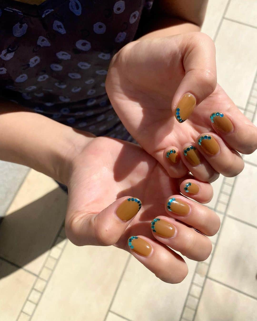 郡司りかのインスタグラム：「今月のネイル🧞‍♂️ 秋を先取りしてベースはブラウンだけれど、爪先のブルーがまだまだ夏っぽくてよい！！  スパンコールがキラッと光って、見ているだけで爽やかな気持ちになる🫐なんかマイナスイオンまで感じる。  このスパンコールの置く位置とか何個のせるかとかそういうのが全てドンピシャで、やっぱりみづきさんセンスすきだ🥺🙏  いつもありがとうございます♡  @lilybeautynail  @bmoon_mizuki   #秋ネイル #ブルーネイル #シンプルネイル #ショートネイル #lilybeautynail」