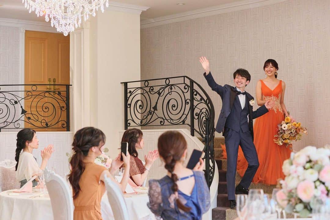 家族挙式のインスタグラム：「. お気に入りのカラードレスへお色直し後は プリンセスのように階段入場✨  笑顔溢れるおふたりと華やかな衣装を ゲストみなさまが写真に収めます📸  会場：セントアクアチャペル星ヶ丘 . -------------------- @kazoku_wedding をフォローして、 #家族挙式 でお写真を投稿してくださいね＊* ----------------------- . “家族挙式ベスト“なら 【挙式・衣裳・美容・写真】が含まれた プランが99,000円〜叶います＊ ▽予約はTOPのリンクから❁ >>> @kazoku_wedding  ------------------- #家族挙式 #ベストアニバーサリー #家族 #Family #bestanniversary #少人数婚#ウェディング #結婚式準備#結婚式 #フォトウェディング #プレ花嫁 #卒花#日本中のプレ花嫁さんと繋がりたい #花嫁#卒花嫁#国内挙式 #ウェディングドレス #プラコレ #DRESSY花嫁 #花嫁コーデ #花嫁コーディネート #披露宴会場 #カラードレス #お色直し #パーティー会場 #結婚式場 #階段入場 #愛知花嫁 #2023秋婚」