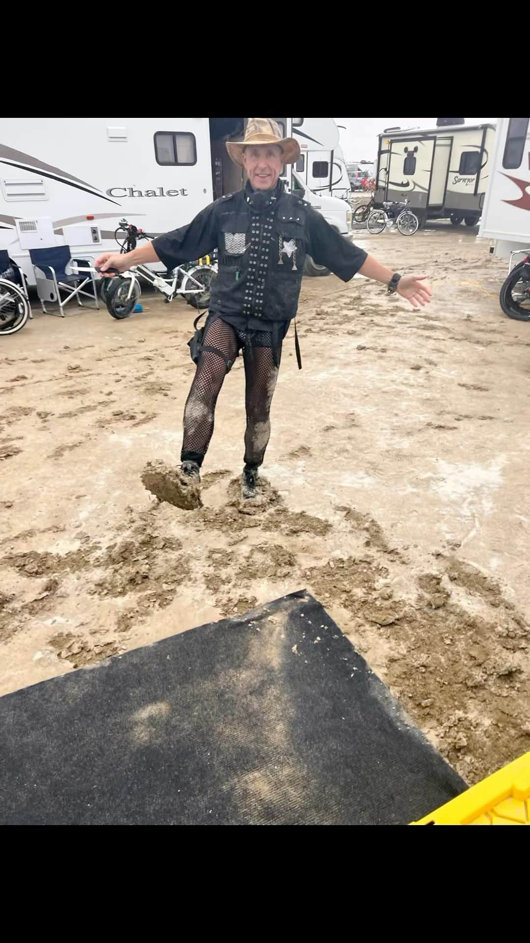 デイヴ・アスプリーのインスタグラム：「So… I’m one of the many people stuck at #burningman in the incredible mud. If you’re worried, don’t be. People here are kind. I am lucky enough to have food and warmth.  This is my 9th time at the burn, and it’s fun every time. Even when the unexpected happens.  Yesterday I was one hour’s dry walk away from my camp when it started raining. I rode my bike for exactly 20 feet before the mud locked up my front tire and I wiped out.  So I trudged for 2 1/2 hours through the rain in the stickiest mud you have ever seen, with about 15 pounds of it on each boot. Wearing a white fur coat caked with mud. Best leg workout of my life…」