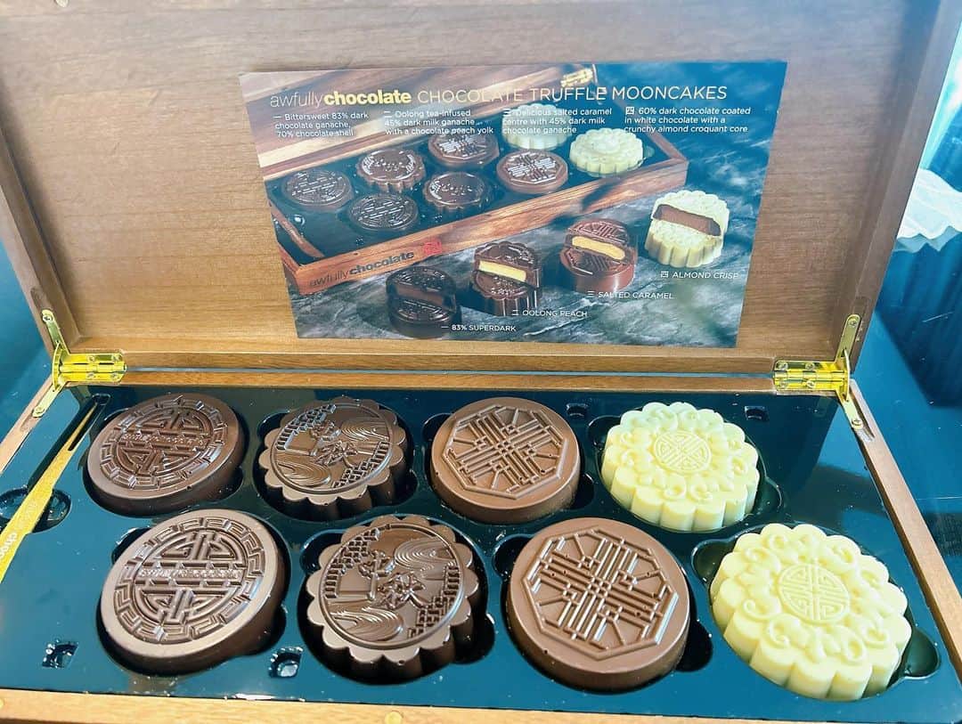 福田萌のインスタグラム：「🥮今年の月餅🥮  シンガポールは9月は中秋節（中秋の名月）のお祝いがあります。  言うなれば、バレンタインとお中元とお歳暮が一度に来たような感じ？でお世話になっている人に月餅を贈り合う習慣が！  ホテルやレストランがいろんな月餅を出していて、箱もこだわっていたりして、今年はどこのを食べようかな〜と悩むのも楽しい😃  前回の投稿ではスタバのバラ売りの月餅をいただきましたが、バラは珍しく、大体が大きな箱入りの5000円以上するものがほとんど🥮  で、今年は、チョコレート屋さんの「Awfully Chocolate」のチョコ月餅にしてみました！  皮が全部パリパリチョコになっていて、なかに餡が入ってる😍😍  これって月餅？って感じの変わり種ですが、チョコ好きにはたまらんです🤤🤤🤤🍫  他にも気になる月餅があるけど、買おうかどうしようか…。きっと今年も誰かからもらった月餅が家に来るかもしれないし…と嬉しい悩みどころです。  皆さんの今年の月餅は決まってますか？」