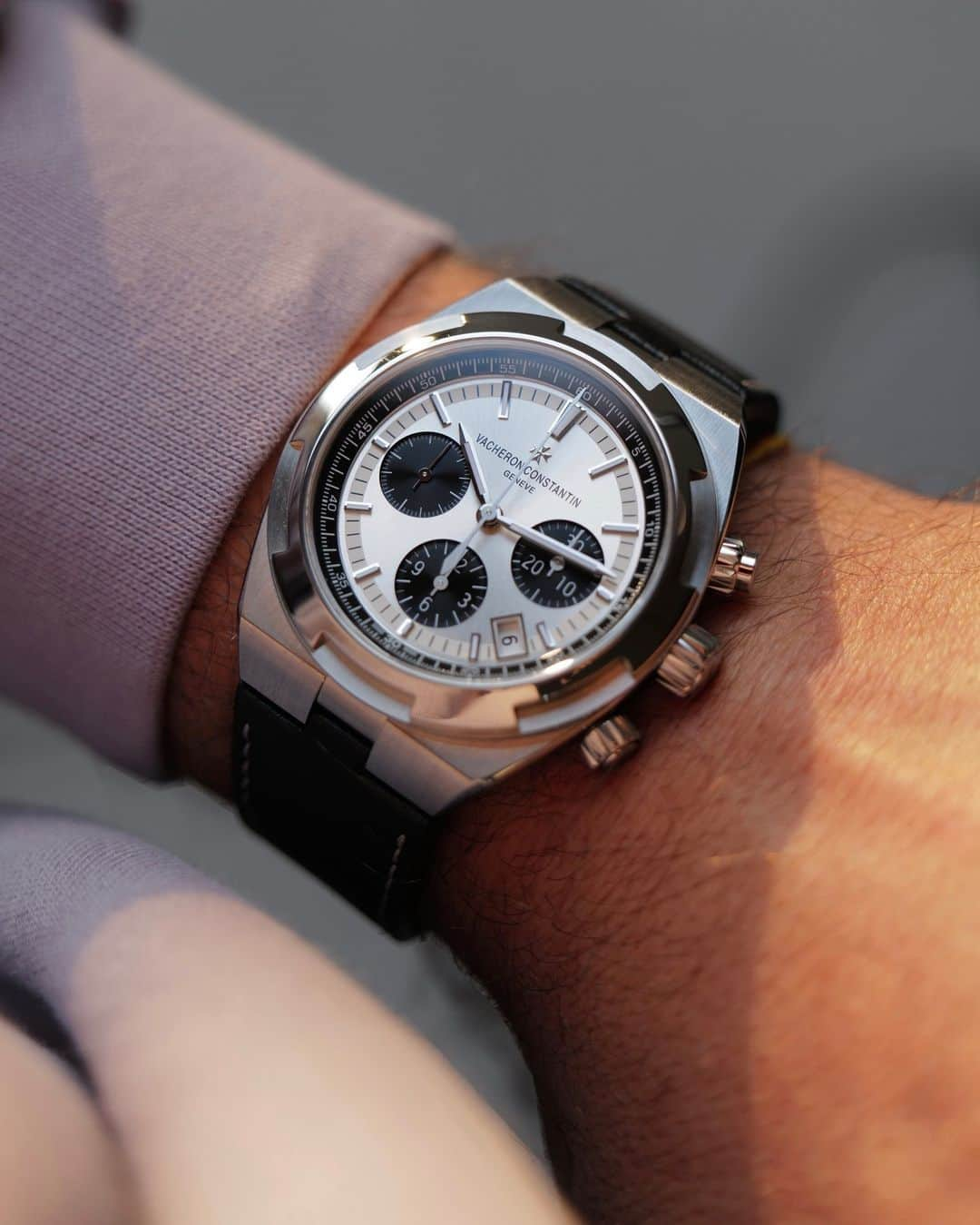 ヴァシュロン コンスタンタンのインスタグラム：「Black & White ⚫ ⚪  Since their creation more than 20 years ago, Overseas chronographs have always been synonymous with exploration for the Manufacture.  In keeping with this daring spirit, the collection now includes a chronograph in a new steel "panda" version: silver-toned, sunburst satin-finished dial, snailed black counters, black velvet-finished flange, 18K white gold hour-markers and hours, minutes, seconds and counters hands, highlighted with Super-LumiNova®.  Picture courtesy of @justinhast  #VacheronConstantin #OneOfNotMany #vacheron #thehourlounge #watches #watch #watchesofinstagram #vcoverseas」