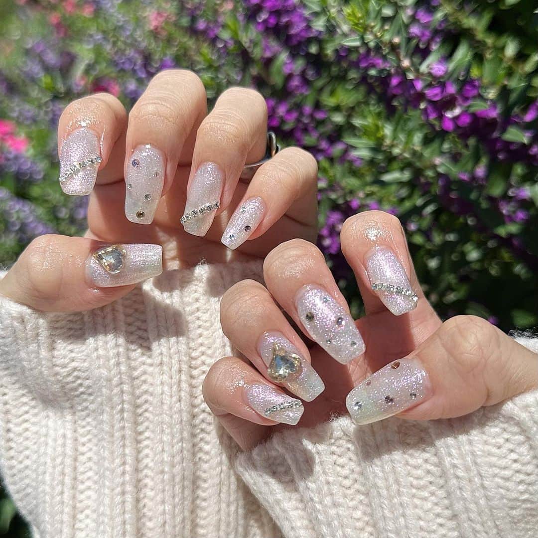 ひなたろす（佐原ひなた）のインスタグラム：「newnail🤍🤍🤍🤍  ホワイトのラメベースでキラキラネイル💅 @bmoon_mizuki さんいつもありがとうございます♡ いつもお話ししてたら爆速でおわっちゃう🤣 毎月可愛いネイルありがとうございます♡  みんなも銀座店ぜひいってみてね🤍🤍🤍  #ラメネイル #ハートネイル #nail #ネイルデザイン #ジェルネイル #ハートネイルデザイン #キラキラネイル ネイル #韓国ネイル #シンプルネイル #カラフルネイル #ホワイトネイル  #ぷっくりネイル #ピンクネイル #follow #following #トレンドネイル #ちゅるんネイル　#春ネイル」
