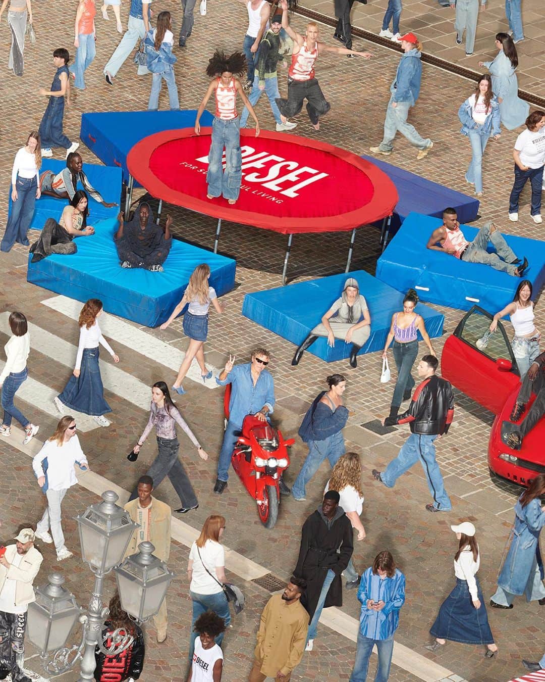 ディーゼルのインスタグラム：「Chance encounters.  A bodybuilding sunbathing on the hood of a car. People carrying watermelons. All of them wearing looks from the #DieselFW23 collection.  The campaign, titled "Find the D”, is a Diesel-fueled ode to children's puzzle game books where the goal is to find a person, place or thing hidden in an image packed with action.  Creative Director @glennmartens, Art Director Christopher Simmonds and Photography @johnnydufort shot the campaign in Breganze, Italy, where Diesel is based, using hundreds of staff members, including @renzorosso.  See more from the campaign at the link in bio.  #ForSuccessfulLiving」