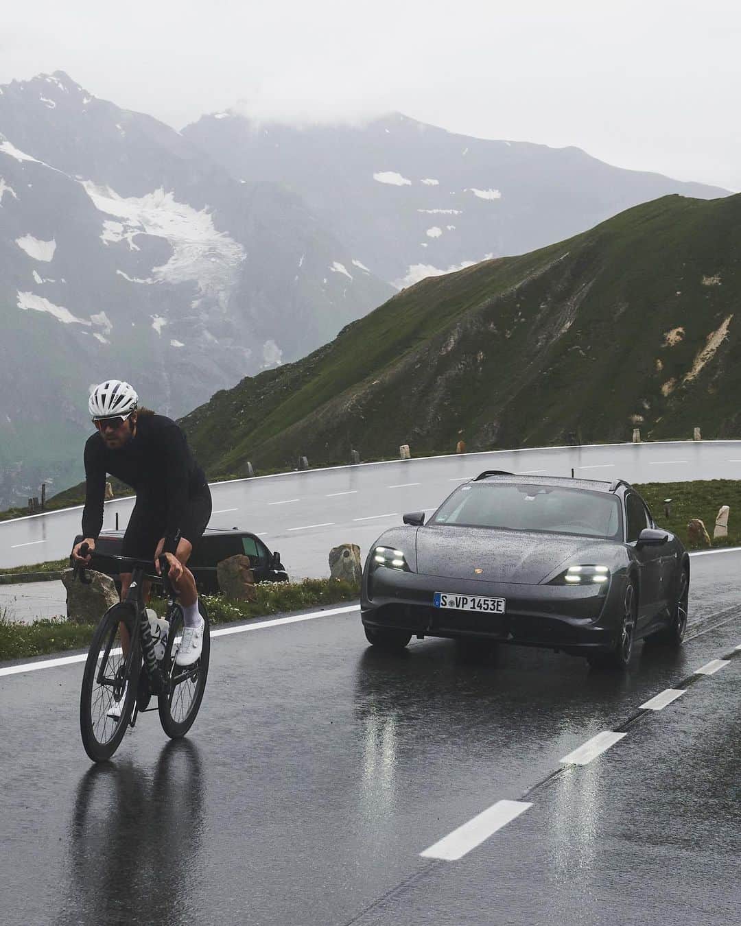 Porscheのインスタグラム：「When human and electric power meet, it’s all uphill from there.  Thunder, sun, then back to pouring rain. Everything on the mountain can change in an instant. In these gruelling conditions, professional cyclist @rickzabel tests his limits on the Grossglockner mountain pass, with the Porsche Taycan Turbo Cross Turismo as his trusty companion. Read the story. Link in bio.  *Closed road. Professional driver* __ Taycan Turbo Cross Turismo: Electrical consumption combined in kWh/100 km:  24,2 - 21,3 (WLTP); Range combined in km:  423 - 483 (WLTP), Range City in km:  533 - 613 (WLTP); CO2 emissions combined in g/km: 0 (WLTP) I https://porsche.click/DAT-Leitfaden I Status: 09/2023」