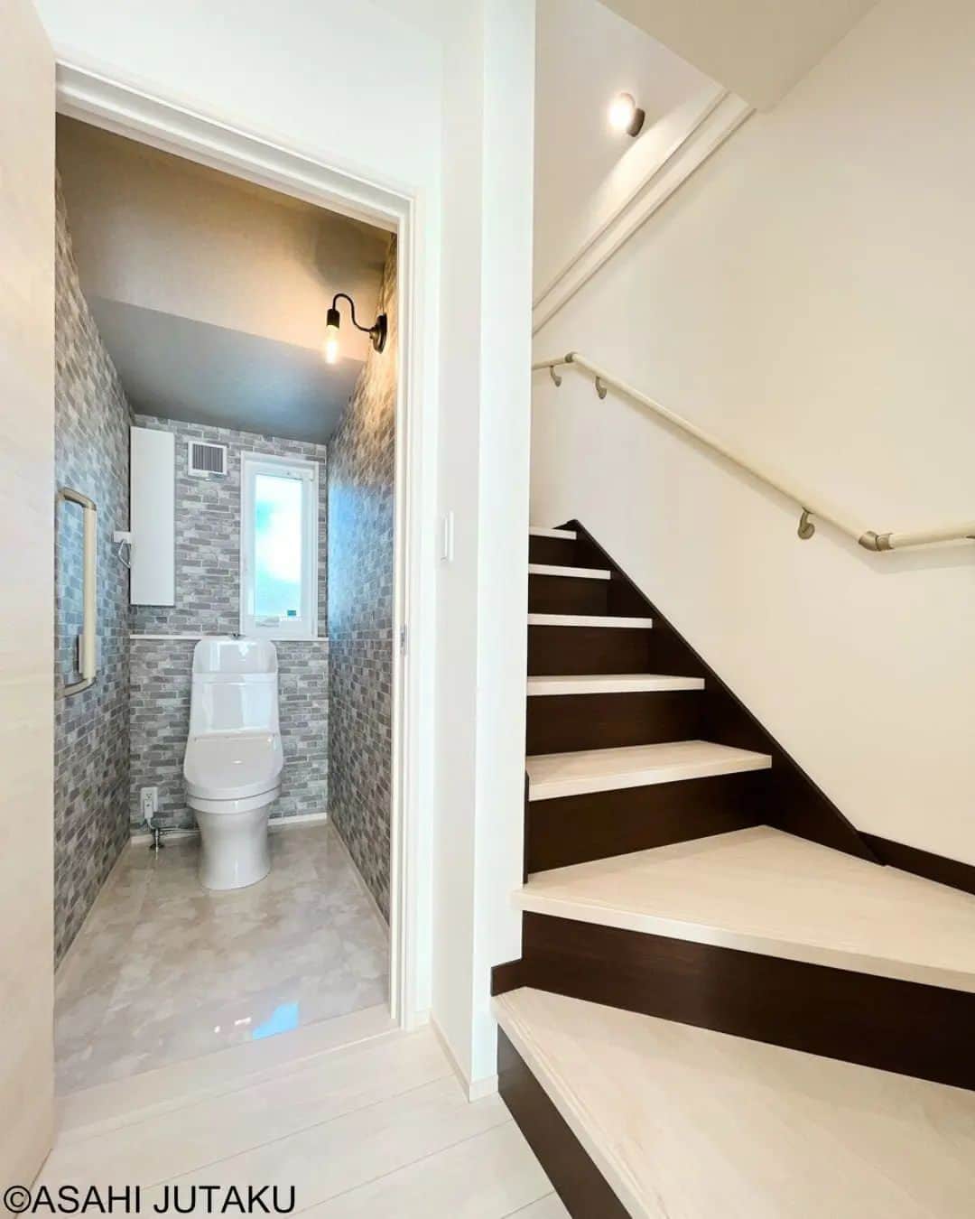 朝日住宅株式会社さんのインスタグラム写真 - (朝日住宅株式会社Instagram)「《階段＆トイレ》  階段下を有効活用したトイレにはブロック柄が特長的なアクセントクロスをチョイス。 レトロな雰囲気の灯りが空間を優しく照らします✨ 全体的に白が基調の階段にダークブラウンの蹴込み板がとてもマッチしています。  ✜✜✜✜✜✜✜✜✜✜✜✜✜✜✜✜✜✜✜✜✜✜✜✜　　　　　　　　　　　　　　　　　　施工例をもっと見たい方は こちら⇒ @asahijutaku　　　　　　　　　　　　　　　　　　　　　　　　　　　　　　　浜松笠井展示場ご見学希望の方は こちら⇒ @asahijutaku.hamamatsu　　　　　　　　　　　　　　　　　　　　　　　　　✜✜✜✜✜✜✜✜✜✜✜✜✜✜✜✜✜✜✜✜✜✜✜✜  #階段下施工例　#ブロック柄アクセントクロス　#トイレと階段 #朝日住宅 #住宅　#住宅デザイン　#インテリア　#マイホーム #マイホーム計画 #家づくり #おうち時間 #こだわりの家 #施工例 #新築 #一戸建て #注文住宅 #自由設計 #規格住宅 #高気密高断熱 #免疫住宅 #全館空調 #丁寧な暮らし #静岡県西部　#静岡県西部注文住宅 #磐田市 #磐田市住宅会社 #磐田市注文住宅 #浜松市 #浜松市住宅展示場 #浜松市モデルハウス」9月4日 12時14分 - asahijutaku