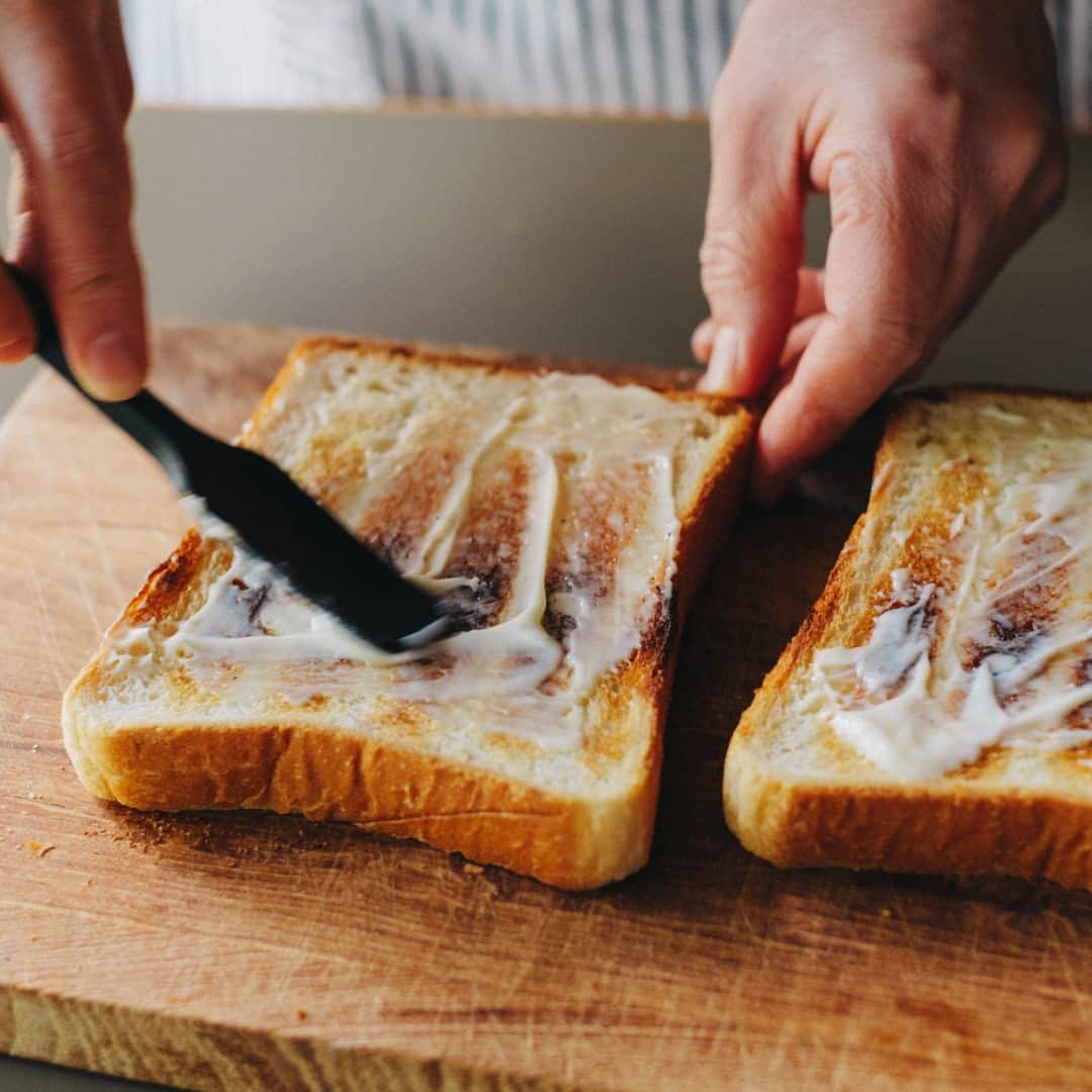 北欧、暮らしの道具店さんのインスタグラム写真 - (北欧、暮らしの道具店Instagram)「おいしさの秘密は重ねる順番。 とろっと卵とチーズが嬉しい「定番サンドイッチ」 . - - - - - - - - - - - - - - - - - 思わずごきげんになってしまう サンドイッチレシピを教えてくださるのは、 料理家の小堀紀代美（こぼり きよみ）さんです。  家にある材料ですぐできる、 定番のサンドイッチをご紹介します。 . - - - - - - - - - - - - - - - - - いちばんシンプル、いちばんおいしい。 小堀さん家の定番朝サンド - - - - - - - - - - - - - - - - -  【材料（2つ分）】 食パン…2枚（6枚切り） レタス…2〜3枚 ハム…1枚 チーズ…1枚 トマト…2枚（1cmほどの輪切りで） 卵…1個 バター…10g マヨネーズ…大さじ1  ※今回のレシピではももハムとゴーダチーズを 使用していますが、スライスチーズなど お好みの種類でOKです  【下準備】 レタスはほんの少しの塩（分量外）をふって 食パンの大きさよりやや小さめに 折りたたんでおく。  【作り方】 ❶食パンはトーストして、 両面の内側にマヨネーズをぬる。  ❷スクランブルエッグを作る。 卵をボウルに溶きほぐし、 塩少々（分量外）を入れてよく混ぜる。 フライパンにバターを入れて 強めの中火にかけ、バターが溶けたら 卵液を入れる。 ゴムベラで大きくまとめて 半熟のうちに取り出す。  ❸パン、トマト、ハム、チーズ、 スクランブルエッグ、レタス、パンの順に 重ねたら、上からぎゅっと押して馴染ませる。  ❹大きめにカットしたクッキングシートの 中央にサンドイッチを置く。 シートの上下の端をあわせて、 1cm幅で折りたたんでいく。 左右の端は上から押さえながら三角形に折り、 底面のほうに折り曲げる。 半分にカットしたら完成。 . - - - - - - - - - - - - - - - - - ■ 小堀さん  「サンドイッチをべちゃっとさせずに おいしく作るコツは、 パンの内側にバターやマヨネーズなどの油脂を しっかり塗ること。  それから、重ねる順番も大切です。 今回だと、チーズの上に 温かいスクランブルエッグをのせることで とろっとした食感が楽しめます。 ハムやチーズの塩気でレタスを食べたいときは、 それらを隣どうしにするのもいいです。  色々試して、おいしい重ね方を 見つけてみてくださいね」 . - - - - - - - - - - - - - - - - - . #kitchen#kitchendesign#kitchenware#food#foodstagram #サンドイッチ#レシピ#サンドイッチレシピ#お弁当#ランチ#お昼ご飯#夜ご飯#今日のごはん#小堀紀代美 さん#家じかん#料理#キッチン#キッチン雑貨#シンプル#シンプルライフ#シンプルデザイン#暮らしを楽しむ#日々の暮らし#北欧#暮らし#北欧暮らしの道具店」9月4日 17時01分 - hokuoh_kurashi
