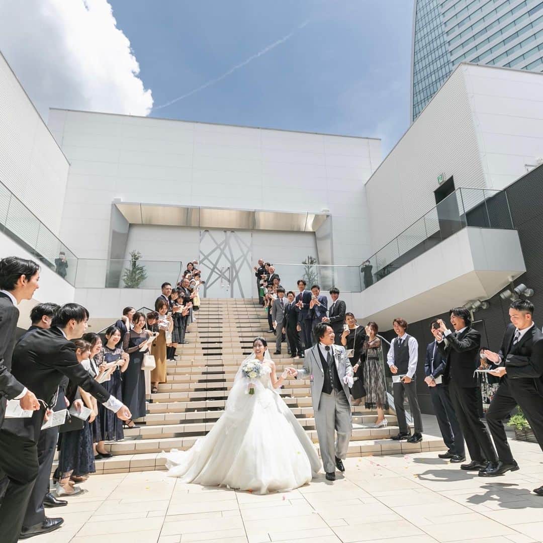 【公式】アルカンシエルリュクスマリアージュ名古屋さんのインスタグラム写真 - (【公式】アルカンシエルリュクスマリアージュ名古屋Instagram)「【青空のフラワーシャワー☀️🥰】  アルカンシエルは8階建ての結婚式場です⛪️ その最上階にチャペルコートがあり、空に近い場所で祝福のフラワーシャワーを行って頂けます💓  階段を降りて振り返って頂くと、ゲストの方がずらり👏圧巻ですね🌟 大切な方との思い出に残るセレモニーとなりました🎉  💒名駅徒歩5分の結婚式場  『#感謝を式のまんなかに。』をテーマに、青空を貸切る祝福のステージと上質な空間で生まれる、ゲストとの忘れられない一日のつくりかたを紹介しています💓  👇🏻をタップ🌈👣 @arcenciel.luxenagoya  2023年度版　JapanBrandCollectionに掲載されました 公式アカウント⇨ @japanbrandcollection lit.link/japanbrandcollection  #アルカンシエル #アルカンシエルluxemariage名古屋 #アルカンシエルリュクスマリアージュ名古屋 #アルカン花嫁 #名古屋花嫁 #名古屋プレ花嫁 #名古屋ウエディング #名古屋ウェディング #名古屋結婚式 #名古屋結婚式場 #愛知花嫁 #日本中のプレ花嫁さんと繋がりたい #結婚式レポ #結婚式レポート #ウエディングレポート #ウェディングレポート #ウェディングレポ #ウエディングレポ #花嫁レポ #結婚式当日 #2023秋婚 #2023冬婚 #2024春婚 #フラワーシャワー #幸せのおすそ分け #アフターセレモニー #結婚式演出 #挙式演出 #結婚式写真」9月6日 21時00分 - arcenciel.luxenagoya