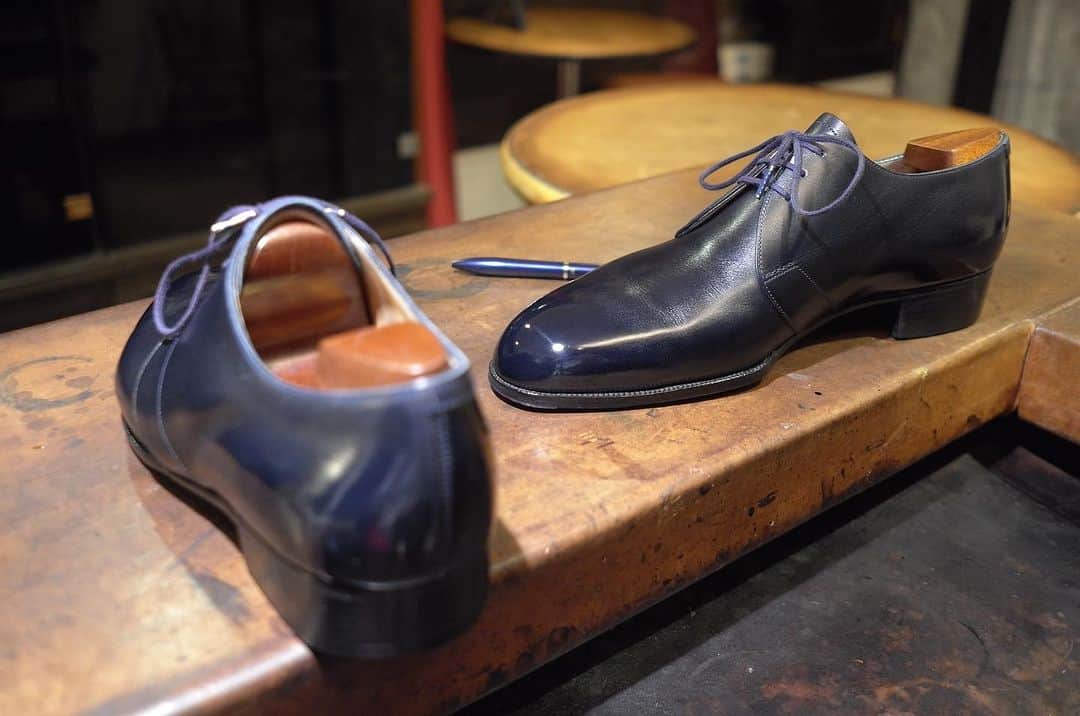 Yuya Hasegawaのインスタグラム：「@johnlobb1849   ジョンロブといえばHERMES資本のパリロブが一般的ですが、オリジンはロンドンはSt.Jamesにあるロンドンロブがそれですよね。靴好きの方はご存知かと思いますが、ロンドンロブは既製品を作ってないので現存する全ての靴が誰かの為だけに作られたビスポークシューズ。こちらのミッドナイトブルーのロンドンロブも某ぼくらのファッションリーダーの方が仕立てた一足。美しい過ぎる、、、たまたま置いてあったボールペンとの色合わせもバッチリです。  #johnlobb #london #brifth #shoeshine」