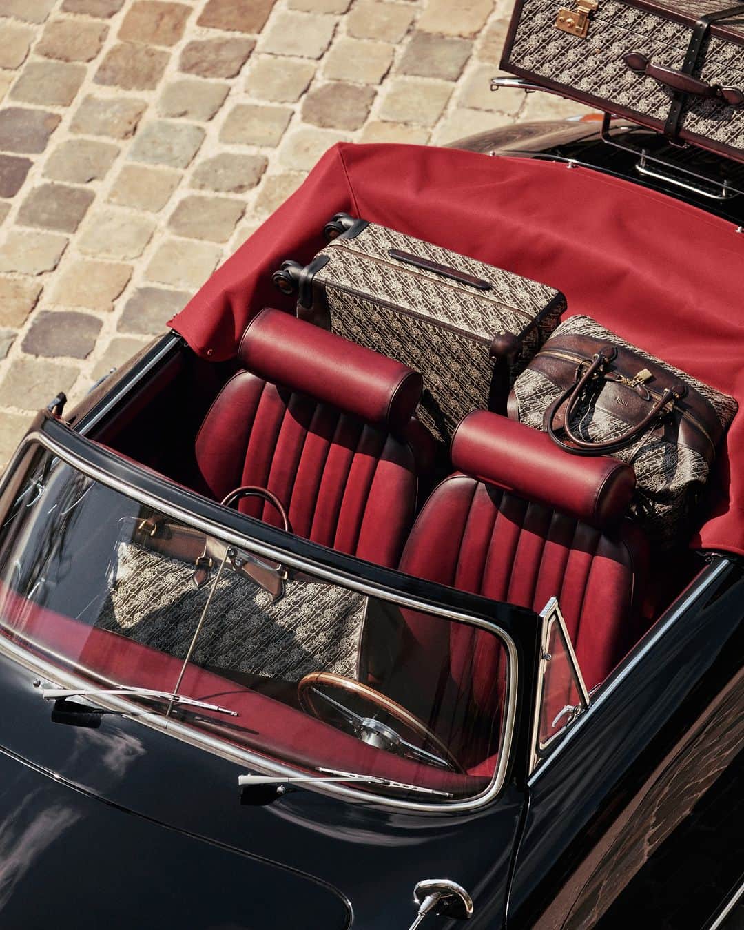 ベルルッティのインスタグラム：「- TRAVEL ICONIC: TOILE MARBEUF BY #BERLUTI -   An effortlessly chic suit. A vintage car with an eccentric twist. A dramatic luggage set: the Berluti man hits the road away from the city skyline and towards the glowing vineyards.   A journey the Berluti way means taking the road less traveled, with a taste for the unexpected along the way. A vintage vibe meets an unconventional take on modernity as Toile Marbeuf suitcases, bags and trunks make their way into a Venezia leather-renewed Porsche 356, its patina complementing the canvas design. Adventure awaits.   Now available online and in-store.  For the occasion, Berluti unveils an original Porsche 356 Cabriolet, customised with Saint-Émilion patinated Venezia leather seats, a baggage rack for unique road trips.  This story takes place at the Château de Saran, at the heart of the @moetchandon estate.  Creative direction by @trendsandculture for Berluti​ Styling by @benmartinengo  Photo by @danielrieraofficial  Model: @thibaudcharon   #BERLUTITOILEMARBEUF   The technical aspects of the car include the Flat 4-cylinder petrol engine, 1,582 cm3 displacement, 60 horse power, and twin carburetors.」