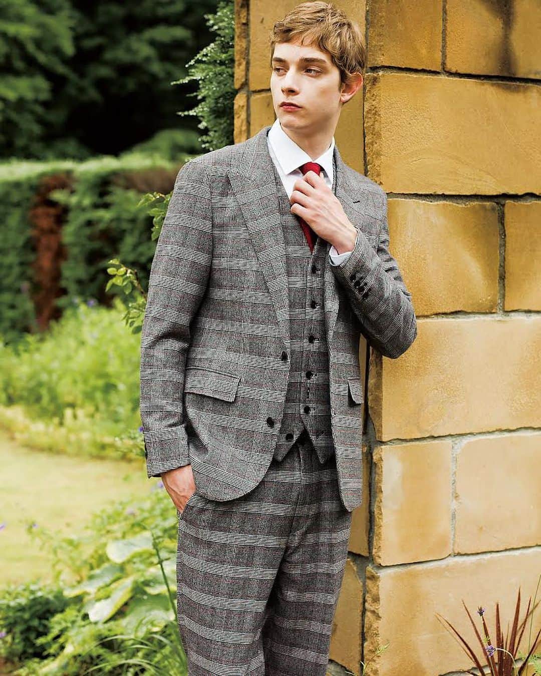 DRESSTERIOR_MEN_ドレステリアのインスタグラム：「. 【赤ペーンがポイントのモダンブリティッシュ|スリーピーススーツ】  品格あふれるクラシカルなイメージのスリーピースを現代的にモディファイしたデザイン。 上品でエレガントな空気感は残しながらも、すっきりとしたモダンなシルエットの各アイテム。 生地には毛織物の産地である尾州で作成したストレッチポリエステルレーヨン素材を使用。 繊細な起毛加工を両面に施すことで、表も裏もふんわりとしたタッチが加わり肌当たりの良い一着となっています。 ストレッチ糸を使用することでタテヨコに伸びる素材となっていて快適な着心地です。 グレンチェック柄をベースにしながらも深みのある赤をペーンに差すことでモダンに昇華しています。 長年スーツ縫製の技術を培ってきた工場で縫い上げていますので、馬の尾を使った「毛芯仕立て」、「袖口の本開き本切羽」、「AMFステッチ」、内ポケットの「お台場仕立て」など、高度な縫製技術によって丁寧に作られたシリーズです。  レッドペーン グレンチェックジャケット ¥49,500(tax in)  レッドペーン グレンチェックジレ ¥25,300(tax in)  レッドペーン グレンチェックパンツ ¥19,800(tax in)  詳しくは @dressterior_men プロフィールTOPにあるURLより オフィシャルサイトへアクセスしご覧ください  #メンズスーツ #スリーピーススーツ #オケージョンシーン #dressterior #ドレステリア ⁡  ------------------------------------------- ▪️dressteriorオフィシャルアカウント @dressterior_official  ▪️メンズ用アカウント @dressterior_men  ▪️ショッププレスアカウント @dressterior_shoppress」