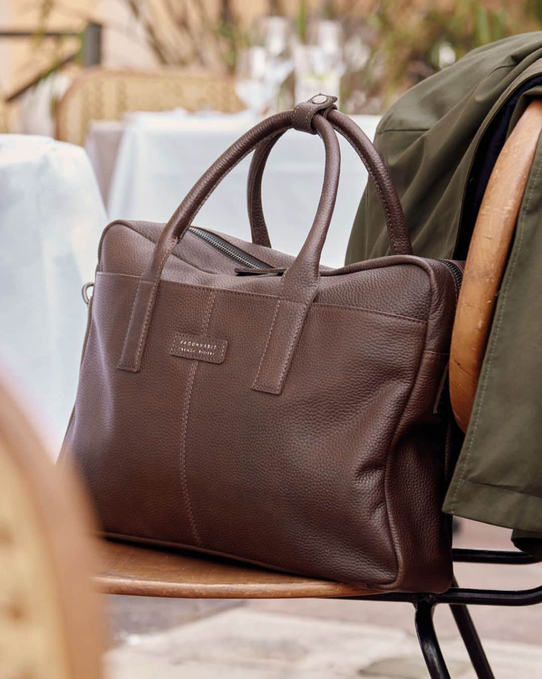 ファッソナブルのインスタグラム：「This rugged and elegant bag features a front snap pocket for easier access, an inside zip compartment and a computer pocket to secure your most precious belongings.  Made in grained leather and showcasing a silver inscription over a leather label to elevate its inherent elegance, it can be carried or worn over your shoulders thanks to its leather handles and adjustable shoulder strap.  #Façonnable  #Amafaçon」