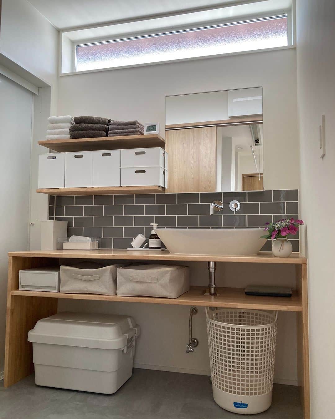 ムクリ［mukuri］さんのインスタグラム写真 - (ムクリ［mukuri］Instagram)「ベースカラー３色をバランス良く取り入れた洗面所と落ち着いた雰囲気を目指したトイレ〜中庭があるロの字型の家（y_home_1225さん）  木と白、グレーをベースにした ３色の配色が、バランス良く調和された Hitomiさんのお家の洗面所とトイレ。  スタイリッシュさとあたたかみの 両方を持ち合わせ、全体のまとまりと 落ち着きを感じる素敵な空間になっています。  収納も計算し尽くされた 使い勝手の良い造作洗面所は 以前の家で暮らしていた経験をもとに 収納の場所と数をしっかり考えた上で 造作を依頼したそう。  グレーをアクセントにしたトイレは 壁排水にし、配管を目立たなくしたり 起こり得る予測も取り入れ ドアを外開きにしたり。  独立した空間だからこそ 使う場面をしっかり想定し ひとつひとつ考えられた細やかな工夫が とても参考になります。 ぜひご覧くださいね♩  @y_home_1225 さん、ありがとうございました！  (編集:maki）  ▶詳細はプロフィールのURLよりご覧ください プロフィールはこちらから @mukuri_official ・  –––––––––––––––––– ムクリ公式アカウントでは くらしの中にある"好き"や"コダワリ"を毎日お届け。  インテリア、整理収納から家づくりなど 日常で参考になる情報から サラッと読める短編コラムまで ご紹介していますのでフォローしてぜひご覧ください。 ▶︎ @mukuri_official ・  「 #ムクリ 」のタグもいつも楽しく拝見しています☺️  オリジナルブランドは @daily_mukuri  くらしの中にあったらいいいな、 そんな商品を企画・制作、集めています。 ––––––––––––––––––  #造作洗面台 #洗面所 #洗面脱衣室 #サンワカンパニー #ハトリアオーバル #洗面ボウル #壁付け水栓 #フロアタイル #タイル壁 #コンセントの位置 #注文住宅 #マイホーム記録 #マイホームアカウント #中庭のある家 #ロの字型の家 #半平屋#くらしの編集#ムクリ」10月4日 21時05分 - mukuri_official