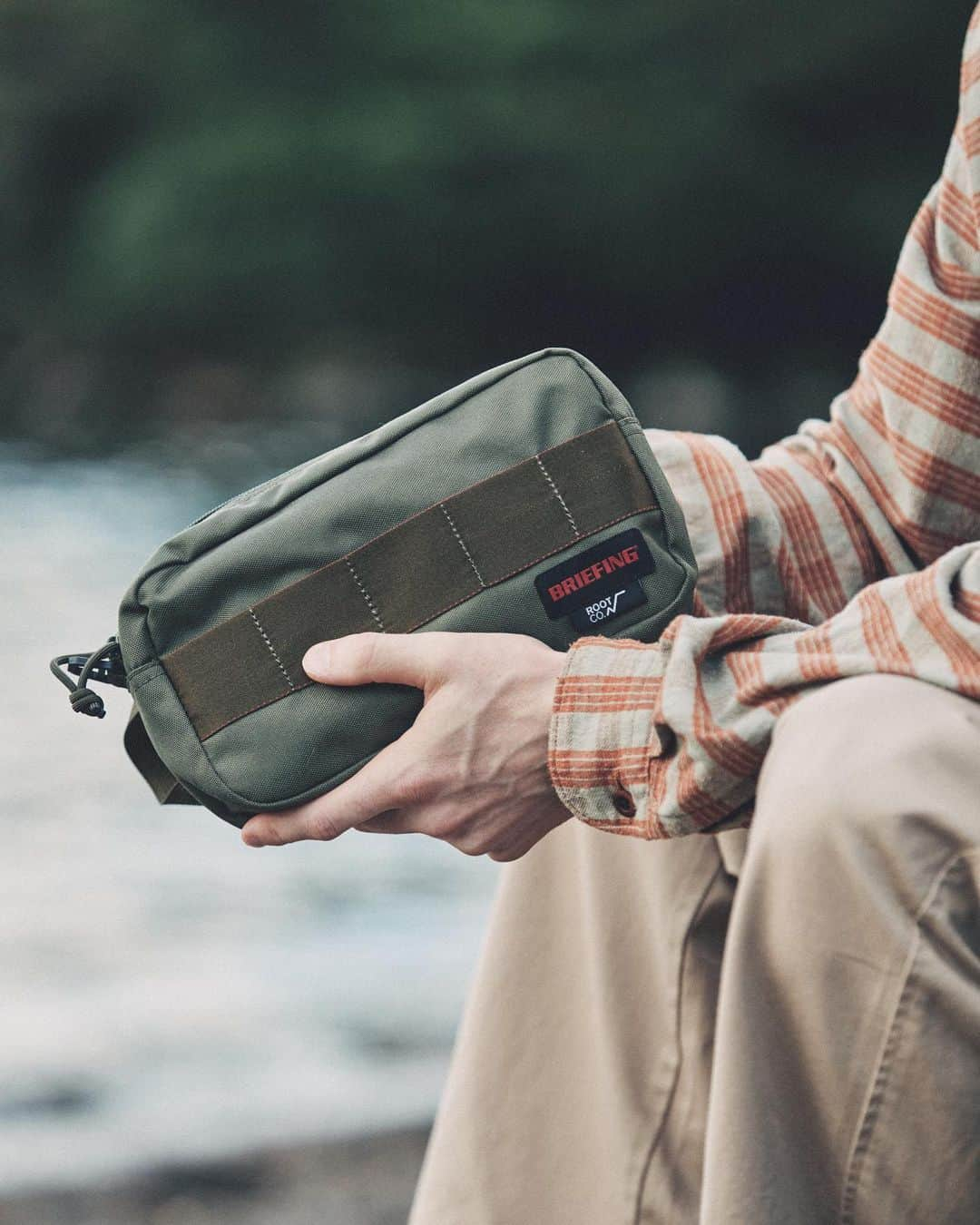 ROOT CO. Designed in HAKONE.のインスタグラム：「. BRIEFING × ROOT CO. @briefing_official  BR × ROOT CO. ONE ZIP POUCH https://www.rootco-shop.jp/c/item/accessory/other/brw231a40  「オンオフ垣根のない環境配慮型アイテム」をコンセプトに、BRIEFINGで展開しているバックパック・キーケース・コインパース・ポーチをデザインベースとした計4アイテムをラインナップ。 各種にBLACK・GRAY・KHAKIというBRIEFINGとROOT CO.ブランドに親和性の高いカラーを落とし込んでいます。 素材にはペットボトルなどのプラスチックを溶かし再生したリサイクルポリエステルを採用。 さらに、全てのアイテムに使用しているDカンはROOT CO.支給のパーツに変更するなど、コラボレーション気分を高める仕様にしています。  大きく開くデザインで大容量の、機能性に優れたワンハンドルジップポーチ。 利用頻度の高いギアの吊り下げを想定し、ファスナーエンド（持ち手側）にROOT CO.オリジナルDカンを配置しました。  #briefing #rootco #root_co」