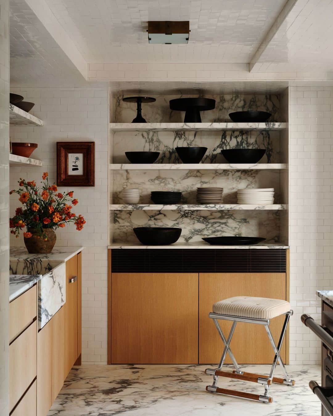 のインスタグラム：「We’ve never met a Calacatta marble-lined kitchen we didn’t like—and this bold black-and-white-veined beauty (in the home of Simon Huck (@simonhuck) and Phil Riportella (@piptherip)) is a total showstopper. Here, designer Michelle R. Smith (@michellersmithinteriors) used marble for everything from the shelving to the sink and floor. The material serves as a focal point against the bright white subway tiles that line the wall and ceiling. Meanwhile, a vintage stove is a fun showpiece addition. All this for a couple who admit they rarely—okay, fine, never!—cook.   Click the link in the bio to tour the rest of this stylish West Village duplex, as featured in our September 2023 Style Issue. Written by Max Berlinger (@isuredontknow). Photographed by @william.jess.laird.」