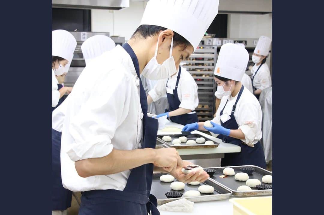 神戸製菓専門学校（公式）のインスタグラム：「🌙お菓子専科(夜1年制)🌙  週に1度の製パン実習でした🍞  前回は菓子パン生地で、 今回はドイツパンの生地を使って #あんぱん を作りました✨🙂  包餡などの工程は復習も兼ねているため、 前回よりも速く、綺麗にできました👏  あんぱんを作る合間に ごまロールも焼いています！😋  お菓子専科では洋菓子以外にも パンやカフェなど＋αで学べます🍞☕️ ---------------------------- 神戸製菓専門学校のお菓子専科(夜1年制)は 関西で唯一、夜間1年で学べる学科で授業スタートは18:10🕕  仕事や大学と両立しながら通っている既卒の方も多く、 「働きながら好きなお菓子を学びたい！」など、 お昼にやりたいことがある方にはぴったりの学科です☺️  2024年4月入学希望の方のAOエントリー受付中❗️ 気になる方は夜間実習見学会でお待ちしています😄  #神戸製菓 #神戸製菓専門学校 #お菓子専科 #夜間部 #製菓専門学校 #製菓専門学校夜間部 #パン #パン実習 #製パン #パン屋 #パン職人 #学びなおし #学び直し #リカレント教育 #社会人学生 #社会人 #大学生 #ダブルスクール #Wスクール #神戸 #三ノ宮 #pattistagram2023」