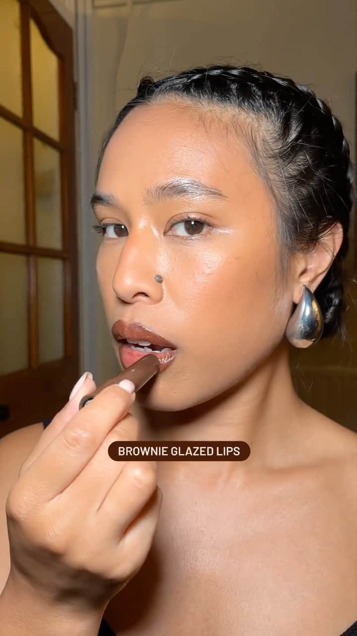 M·A·C Cosmetics BRのインスタグラム：「Por aqui estamos viciados em trends com nome de comida! E já temos a nossa favorita do dia! 🤎 🍫   Com gostinho de sobremesa a @lxstv lxstv ensina como aderir à  #BrownieGlazedLips , a trend é para quem ama um bocão marcante com gloss marrom 🤎✨  Produtos usados no vídeo:  ✨ Lápis Delineador Labial na cor Chestnut  ✨Gloss Plumping em Stick Squirt na cor Lower Cut   #ParaTodoMundoVer: No vídeo a Artista @lxstv lxstv contorna os lábios com um lápis delineador labial marrom escuro e depois aplica um gloss em stick na cor marrom nos lábios.   #BrownieGlazedLips #BrownLips #MACSquirt #GlossSquirt #BrownMakeup #LipCombo」