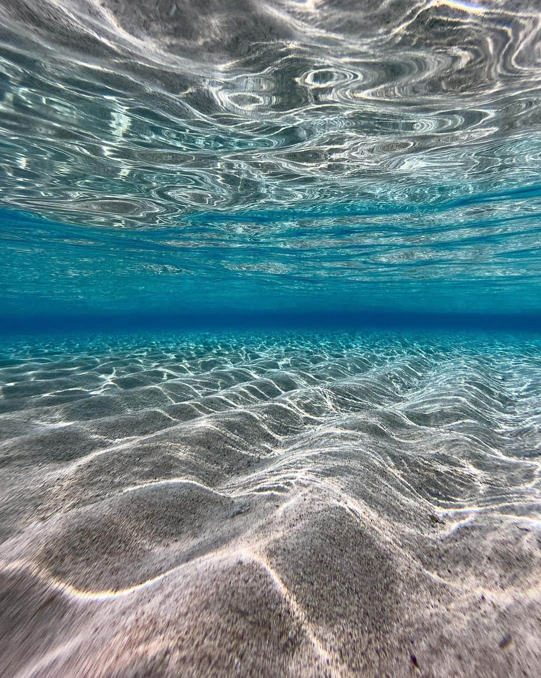 詩歩さんのインスタグラム写真 - (詩歩Instagram)「条件があわないと現れない幻の砂浜🐚 Fantastic sandy beach that does not appear unless the conditions are right.  海岸の1.5Km沖合にある #百合ヶ浜 は、大潮の干潮時にだけぽっかり出現します。私も2014年に出版した書籍「死ぬまでに行きたい！世界の絶景 日本編」で紹介させていただいて、それをきっかけに多くの方が訪れてくれたようで嬉しい限りです🙇�  百合ヶ浜は毎日は見れません。じつは今回は現れない時期だったので、写真は2019年に撮影したもの😛（今回は、星空がキレイに見える日＝新月期を優先したの！百合ヶ浜が見られるのは満月周辺なので、真逆なのがツラい所）　  百合ヶ浜が出るor NOTは、観光協会の公式サイトにカレンダーが載っているから、絶対に見たい人は旅のスケジュールを決める前に参考にしてね！  ちなみに百合ヶ浜が出ない時期でもツアーはやってるから、行くだけ行ってみました。 MAX干潮時でも膝上くらいの水位があるけど、水中は驚くほどクリア😳 2枚目はスマホで撮った水中写真だよ📷　  ユズちゃん🐶にも会えたし、なんとウミガメ🐢にも遭遇✨✨ #大金久海岸 はシーグラスもたくさんあるので探してみてね💎  鹿児島の写真はこのタグでまとめています / Posts of this area can be found in this tag.→ #shiho_kagoshima   Located 1.5 km off the coast, #Yurigahama beach appears only at low tide during high tide. Actually, this time it did not appear, so the photo was taken in 2019. This time, I prioritized the day when the starry sky is beautiful = new moon period! The calendar on the official website of the Tourist Association shows whether or not Yurigahama will appear, so if you definitely want to see it, please refer to it before deciding on your travel schedule! By the way, tours are offered even during the times when Yurigahama beach does not appear, so I just went there. Even at max low tide, the water level is about knee-high, but it's amazingly clear underwater. I was lucky enough to see Yuzu 🐶 and also a sea turtle  during the tour!  🚁ドローンは許可を得ています / Drone photography with permission. 📷 9-11th Sep 2023  📍鹿児島県 与論島 / Yoron Island, Kagoshima Japan  ©︎Shiho/詩歩」10月3日 19時17分 - shiho_zekkei