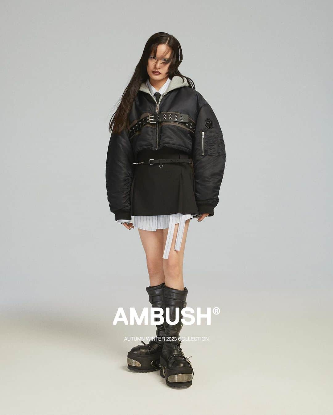 AMBUSHさんのインスタグラム写真 - (AMBUSHInstagram)「The new seasonal bomber in regular and cropped lengths is belted across the chest for an edgier look.  #AMBUSH AW23 COLLECTION LOOK 5  CROPPED BELTED BOMBER STRIPES CROSSED SHIRT DRESS AMBUSH ACADEMY VEST HOODIE PLEATED MINI SKIRT TAILORING SLIM NECKTIE SPIKE PIERCE AW23 CLASS RING SPIKE STUDS BELT KNEE HI RAVE BOOT  Now available at our WEBSHOP and WORKSHOP.」10月3日 19時23分 - ambush_official