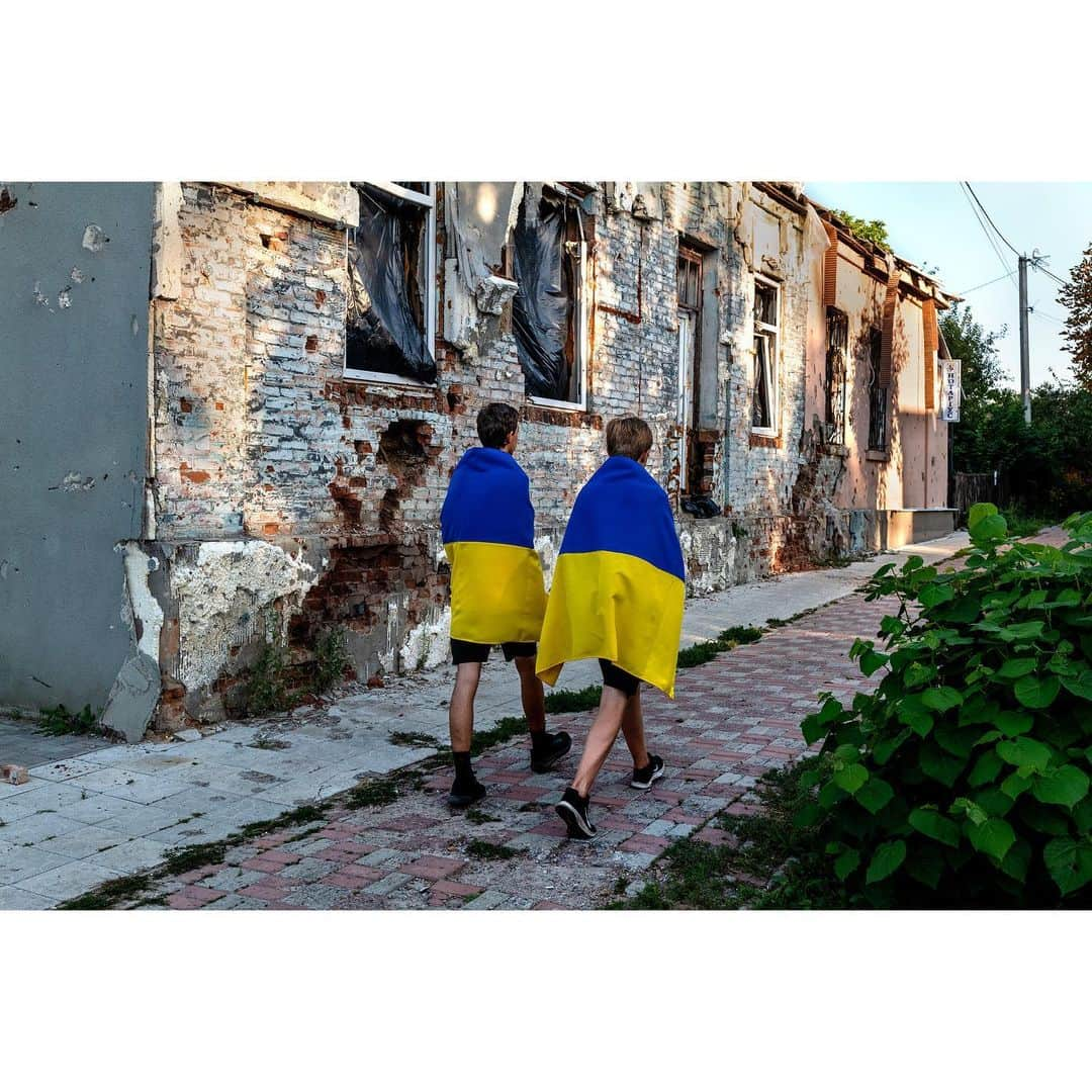 スティーブ・マカリーさんのインスタグラム写真 - (スティーブ・マカリーInstagram)「Two boys draped in their country's flag walk down the street in their neighborhood which was bombed by Russian rockets. Izyum, Ukraine, 2023.」10月4日 5時42分 - stevemccurryofficial