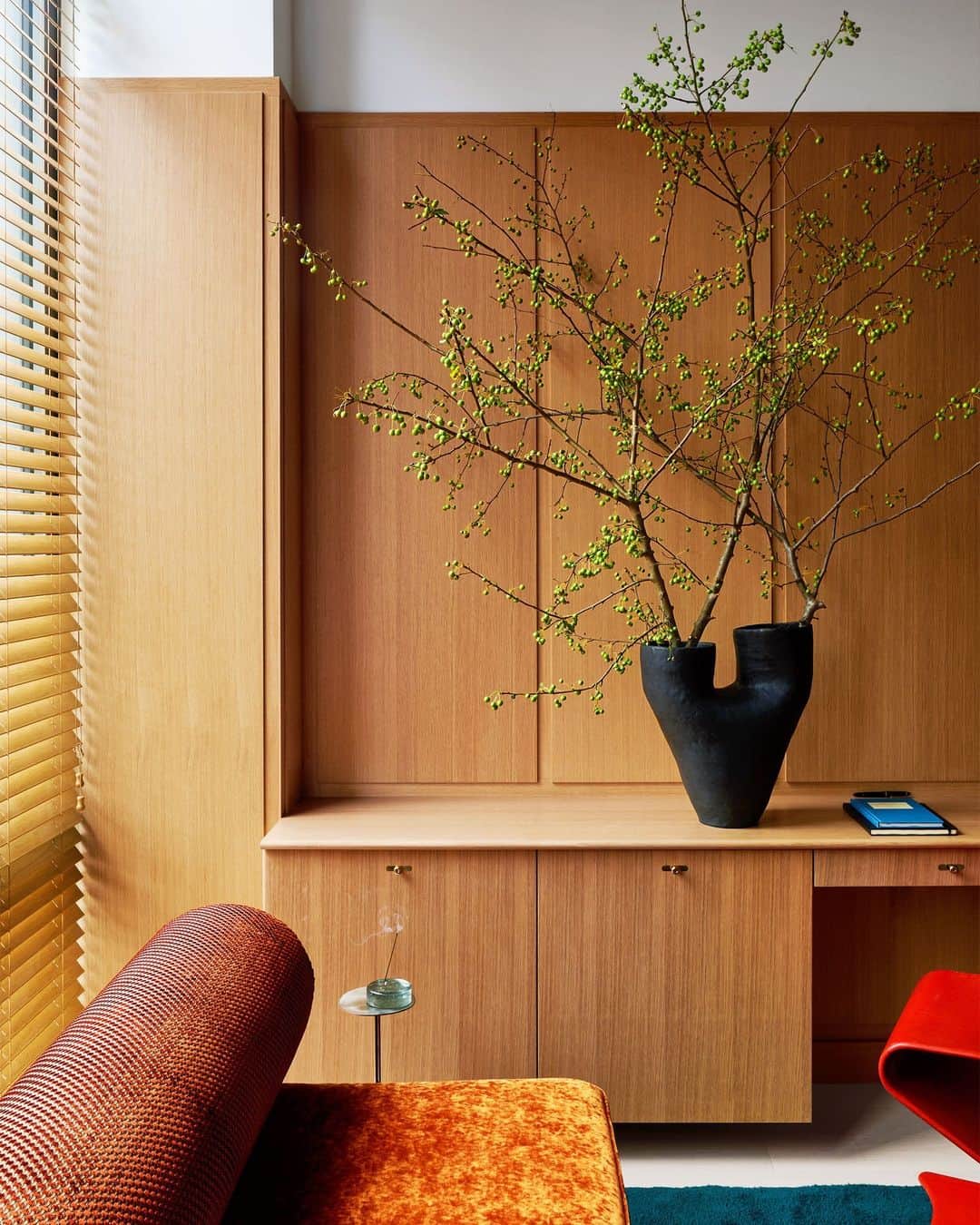 ELLE DECORのインスタグラム：「Warm wood is the name of the game in this combined guest room and office belonging to former WNBA guard Sue Bird (@sbird10) and soccer superstar Megan Rapinoe (@mrapinoe), who know a thing or two about game. Here, ELLE DECOR A-List designer Mark Grattan (@markgrattan) brought in a sofa by Flemming Busk in a @dedarmilano fabric. The rug is from @randcompanynyc, and the vessel is by @nurceramics.   Click the link in our bio for the full cover story. Written by Katherine Bernard (@meta__porter). Photographed by @sans.murs. Styled by @tessawatson.」