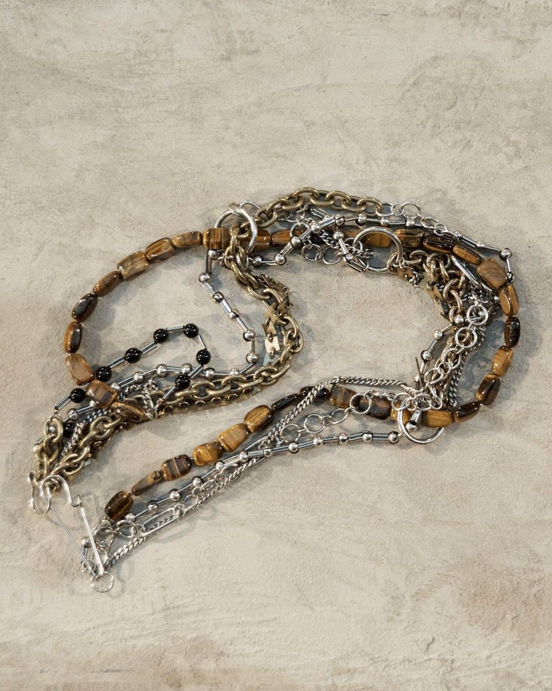 ドリス・ヴァン・ノッテンのインスタグラム：「AUTUMN WINTER 2023 MEN ACCESSORIES  Double chain brass necklace with tiger eye stones and bracelet with onyx stones.  The collection is available in stores and on driesvannoten.com  #DriesVanNoten #DVNAW23」