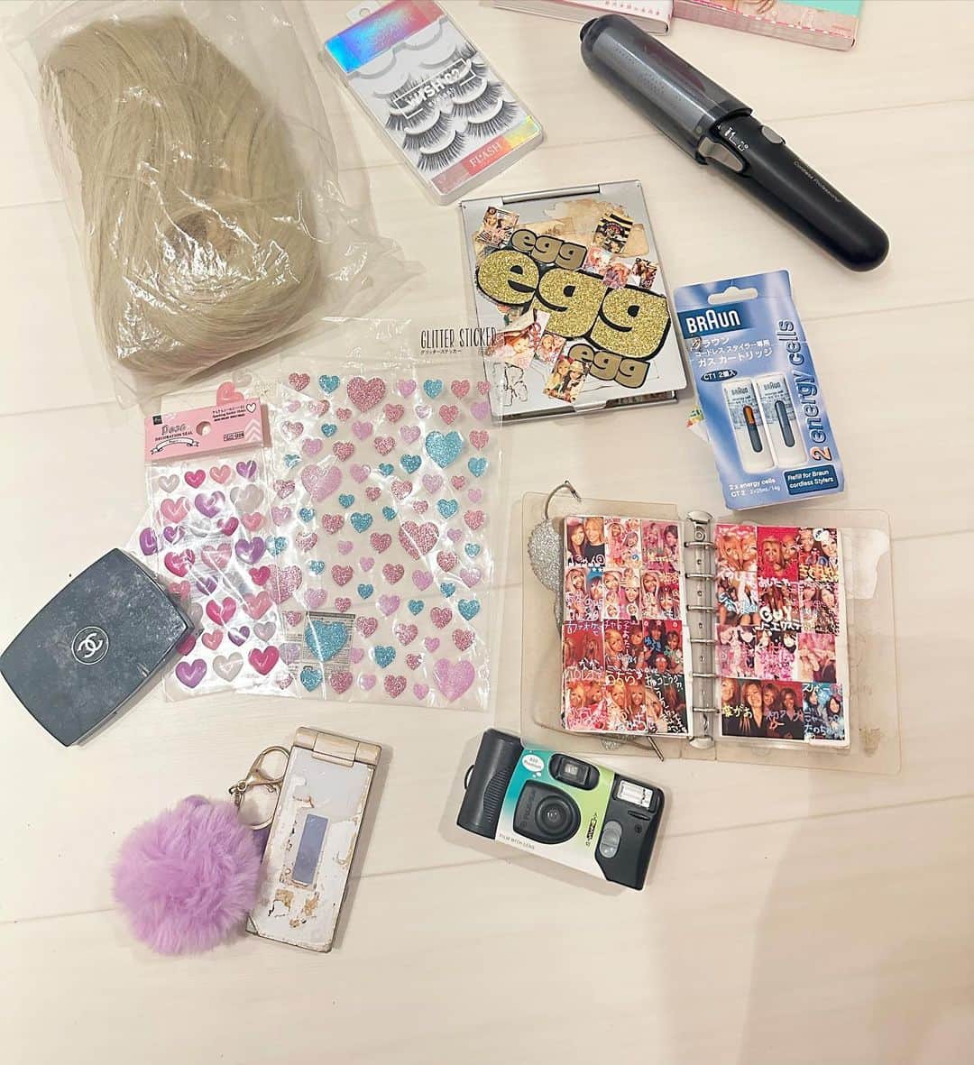 板橋瑠美のインスタグラム：「思い出のあるアイテムを  Y2KのMV撮影に持っていきました♡ ・ ・ ・ 🌺インスタントカメラ 🌺ガラケー 🌺ガスコテ 🌺ガスコテカートリッジ 🌺プリ帳 🌺目の下用シールw 🌺CHANELシェーディングパウダー 🌺つけまつげ 🌺プリ大量ミラー  若い方、 この9個中、知らないものありましたた？？？（ガスコテとか絶対知らないよね？ww）  ウィッグは、最近のだから、除外w  #ギャル　#平成ギャル　#ガスコテ　#ガスで毛先しんだ　#今考えると恐ろしすぎるよねw  #ガスで髪を燃やす危ない器具　#髪のダメージより今しか考えてない　#ギャル最強　#ガスコテのおかげで助かったギャル多数　#今みたいにどこでもコンセントのない冷たい社会 #コンセント使ってマックの店員に何度もブチ切れられた#次使ったら警察呼ぶぞって言われた　#モバイルバッテリー考えた人天才だけどもっと早めに作ってよ？w 　#だから充電難民ならないようにフルに充電したバッテリー三つ持ち歩いてた　#かしこくね？w  #行きにくい時代に生き抜く力の強い生命力こそがまさに　#本物のギャル　#今の時代ならギャル快適に生きれたね　#令和ギャル」