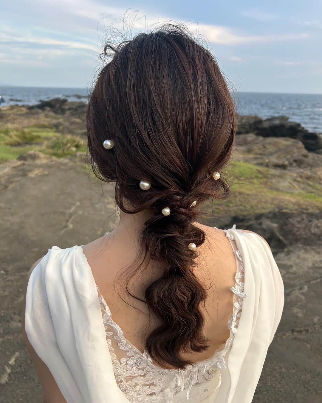 吉田悠希のインスタグラム：「📷🤍 ロケーションフォトでのヘアアレンジ @loana_roppongi  ⁡ ⁡ 城ヶ島での撮影だったので 風が吹いてもほどけないように、 でもゆるーくというわがままなオーダーで🪿🪿 ⁡ ⁡ サイドからランダムにつけたパールUピンは この日に合わせてAmazonで調達しました🛒 ⁡ パールのヘアアレンジやってみたかったから 素敵に仕上げていただけて嬉しかった〜🥹♡ ⁡ ⁡ ⁡ ⁡ #ヘアアレンジ #パールアレンジ #結婚式ヘア #フォトウェディング #前撮り #前撮りヘア #ロケーション撮影 #パールアクセサリー #ヘアメイク #まとめ髪 #編みおろし #編み下ろしアレンジ #プレ花嫁2023 #城ヶ島前撮り」