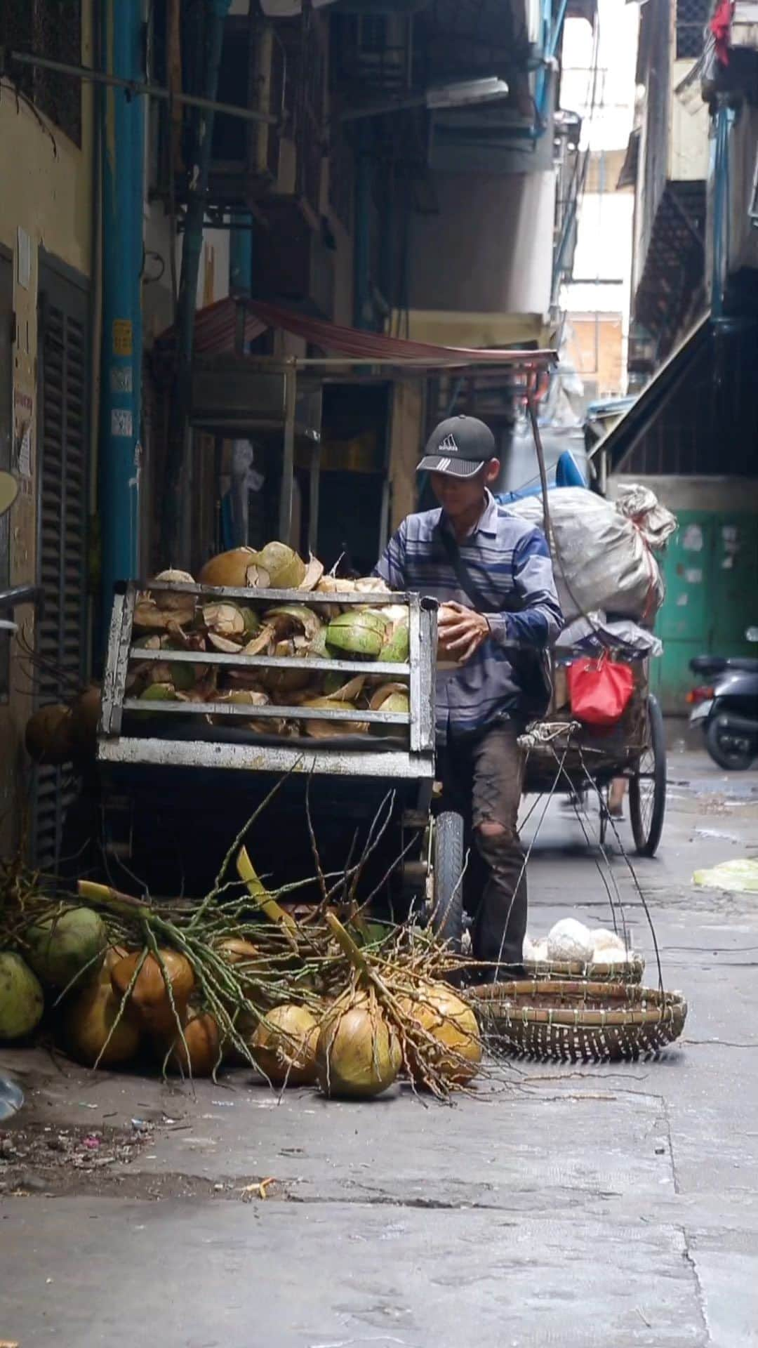 Shunsuke Miyatakeのインスタグラム：「A man working on pealing coconuts 🥥 /  There're bunch of different works on the street of Phnom Penh. He was making coconuts into drinkable shape at the backstreet in the morning. Without such a hard working guy, we can't drink fresh coconut juice on the street. Before the sun rises completely, he finished shaping, and went for selling those fresh coconuts. Hope he can sell a lot 😉🙏🏻🥥」