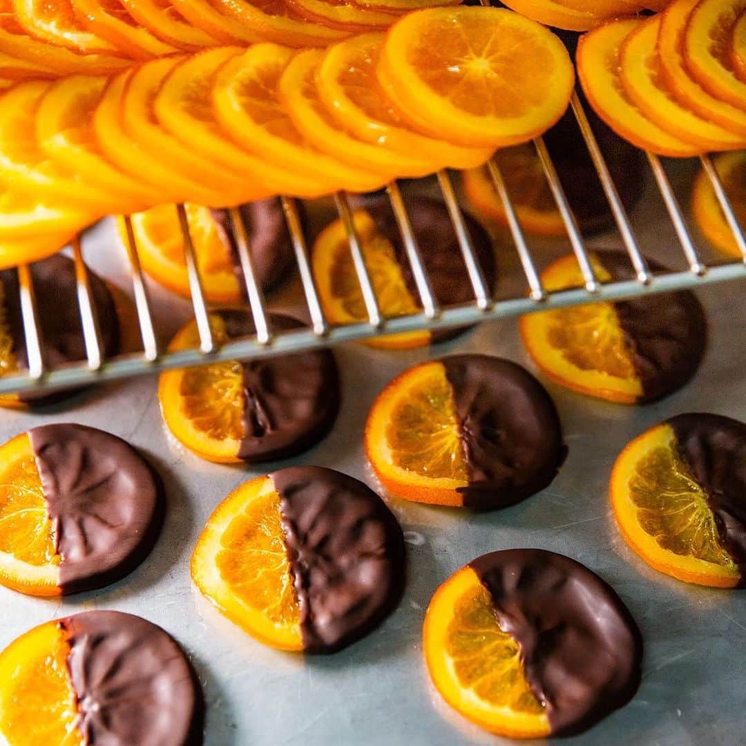 Decadence du Chocolatのインスタグラム：「《バレンシア》  デカダンスのバレンシアは、オレンジの皮のみではなく、輪切りにして果肉があることで、フレッシュさとジューシーさを感じられるのが特徴です🍊✨  また、オレンジのジューシー感を保ったままお客様の元へと届けるために、製造から完成まで短時間で仕上げています✨  バレンシアオレンジの甘酸っぱさと、オリジナルブレンドチョコレートのほろ苦さ、パリッと食感を実現出来ているのも製造工程に工夫があるからなんです😋  デカダンス看板商品のバレンシア、是非ご賞味ください！！！  #バレンシア  #デカダンスドュショコラ  #decadanceduchocolat」