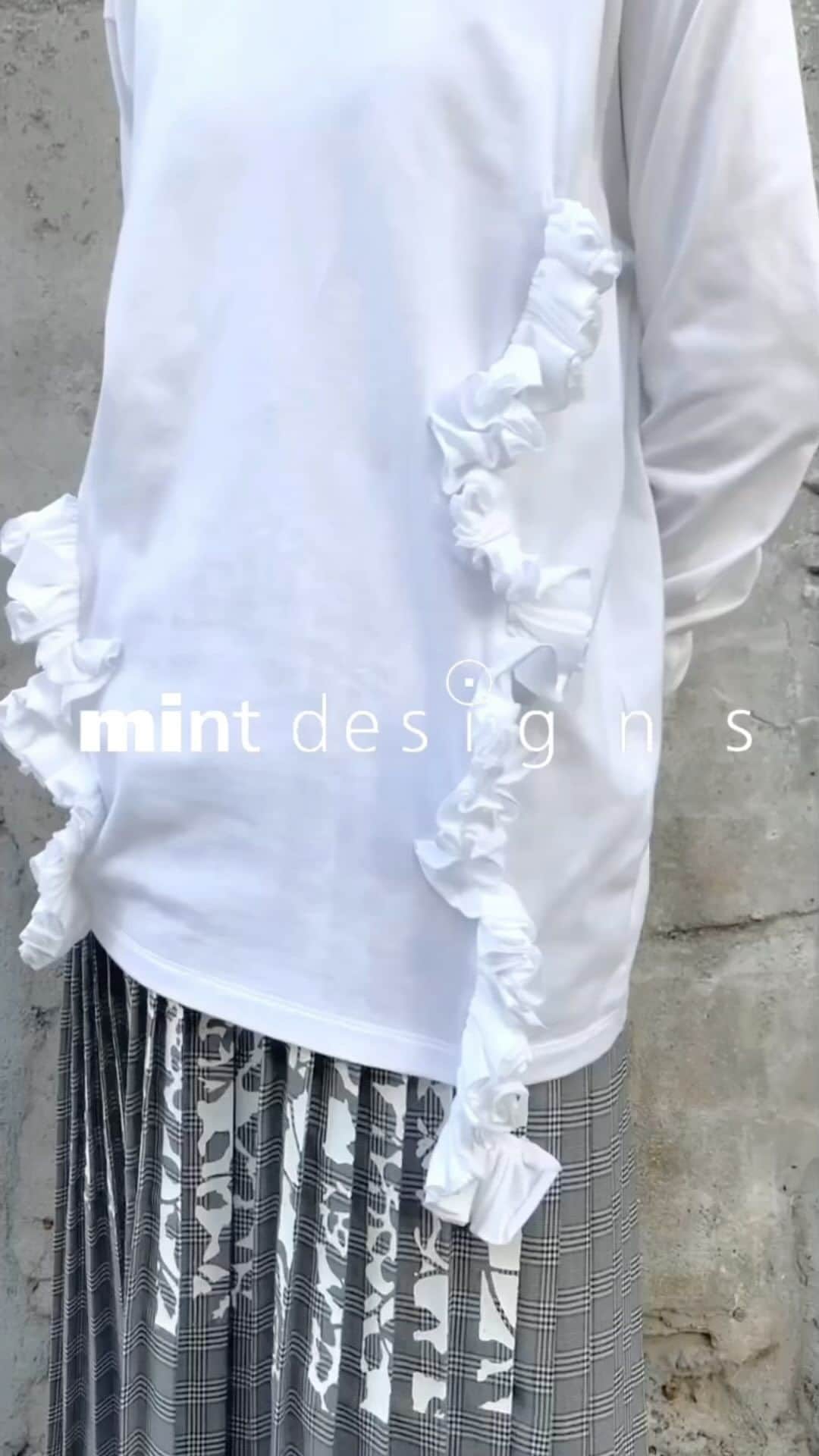 のインスタグラム：「. -LONGSLEEVE FRILL T-SHIRT-  花びらがぎゅっと詰まったようなフリルを施したロングTシャツ。 コレクションピースとしてショーで登場したボリューミーなフリルを、あえてカジュアルなTシャツに落とし込みました。 ロングな着丈でカジュアルさもありつつ、凝ったディティールが華やかさを演出してくれます。  #mintdesigns #ミントデザインズ #2023aw」