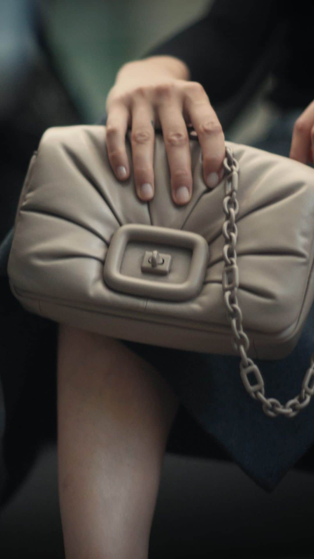 ロジェ・ヴィヴィエのインスタグラム：「The Viv’ Choc bag is Maison Vivier’s newest icon. A testament to our artisanal heritage, it is crafted in draped leather that unfolds from its matching buckle, including a tonal chain-link shoulder strap.  Creative Director: @gherardofelloni  Art Direction: @atelierfranckdurand DOP: @samjohnsondirector Styling: @dogi_  Hair Styling: @yann_turchi  Make up: @anglomamakeup  Production: @collateralfilms_official  Casting: @tommacklinstudio   #VivChocBag #RogerVivierFW23 #RogerVivier #GherardoFelloni」