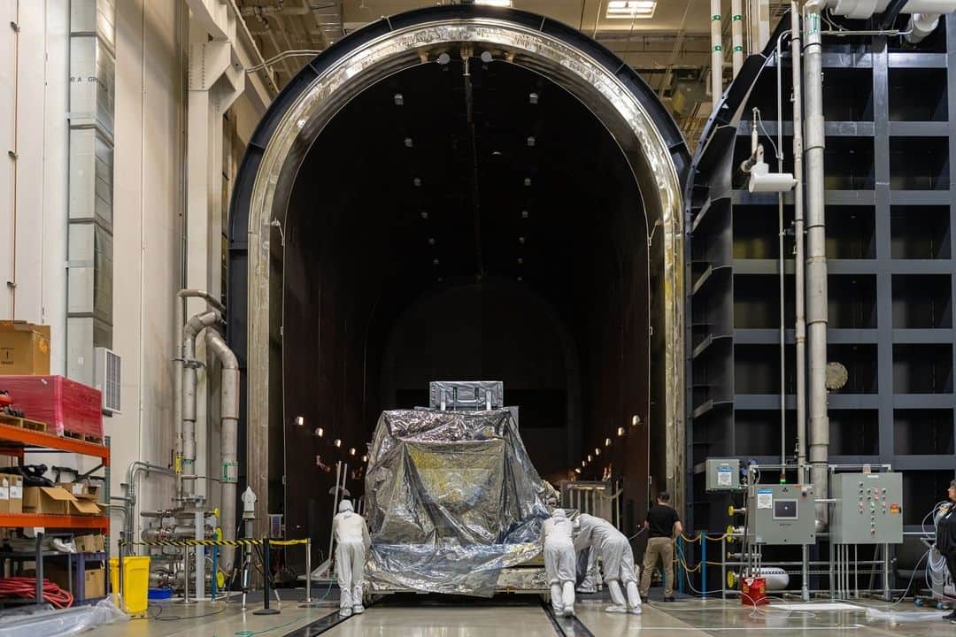 NASAのインスタグラム：「The instrument that will give us some of the largest images of the universe from space has just been completed and is ready for testing!   The Nancy Grace Roman Space Telescope's Wide Field Instrument (WFI) has finished construction at @BallAerospace and is now moving on to environmental testing, ensuring it can withstand the conditions of space and launch!   Check out the link in our bio to learn more about Roman's WFI!   Photo Credit: BallAerospace  Image description: 1: A wide shot of a silvery piece of space hardware about the size of a car sitting on a silver platform. Three techs in head-to-toe white suits are pushing the structure from behind through a very large, arched doorway that leads to a dark room lined with dim lights.   2:  Wide shot of the back of the Roman Wide Field Instrument, seen from this angle as a flat, black panel about as tall as a person and with rectangular flaps extending outward from each side and from the top, on a large silver platform. There are three people in head-to-toe white suits standing to the side of the structure. To the right, there are two people in head-to-toe white suits elevated on a blue crane and inspecting the top part of the instrument.  3: Wide shot, seven people in head-to-toe white suits pushing in a large structure covered in a plastic-looking drape.   4: Wide shot of the Roman Wide Field Instrument. It is a large round cylinder attached to a flat panel. The whole thing is covered in a gray tape-like material.」