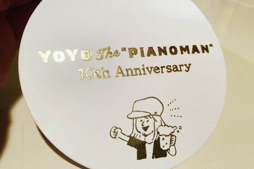 YoYoさんのインスタグラム写真 - (YoYoInstagram)「前々から制作したかったアイテムでもあった「ロックグラス」が10周年記念グッズとして完成〜〜7/2ライブでは大好評の反応ホントに嬉しく(°▽°)  お馴染みのピアノマンイラスト入りグラスですが、グラスの質もグッドクオリティーな業者にお世話になり作り上げる事ができました🎵グラス後ろ面には「10th Anniversary」の文字入り。  そしてそのロックグラスを置くためのコースターも2デザインセットとして完成！ 箔押し入りの「音楽フェスKMJロゴ」と「ピアノマンロゴ&新イラスト」  これら記念グッズ、いよいよ明後日に迫った福岡での「中州ジャズ」へ持って行き販売を行います。他、もちろんCD、アナログ盤等も。  先日smile dining switchへ伺うと、なんと新カクテル"YoYo"が誕生していてメニューにYoYoの文字が！！！(*≧∀≦*) 自分が酔っ払った時にもうひと推しの甘〜いカクテルが飲みたくなった時に、バーテンマスターがイメージを具現化してくれた、どこまでも行けちゃう味👅それが正式にメニュー入り！ピアノマンロックグラスに入ってお客さんへサーブされるという！なんて粋なアイディア🙌嬉。 最終的には２方向を飲み比べまでさせてくれて、方向性を整えカクテル正式完成に！今後も永遠飲んじゃうやーつーデス。  --------------------------- YoYo the "Pianoman" 10th Anniversary Goods ・ロックグラス　¥2,500(tax in) ・箔押しコースター2デザインセット　¥500(tax in) ---------------------------  YoYo the "Pianoman" 中州ジャズ出演は、イエローステージにて、17:10〜となりました！ 思いっきり楽しみましょー！観覧無料です。久しぶりの皆皆さまも中洲大通りへ是非シューゴー思いっきり心から、お待ちしてます。 https://yoyothepianoman.bitfan.id/contents/119228」9月14日 19時34分 - yoyo_soffet