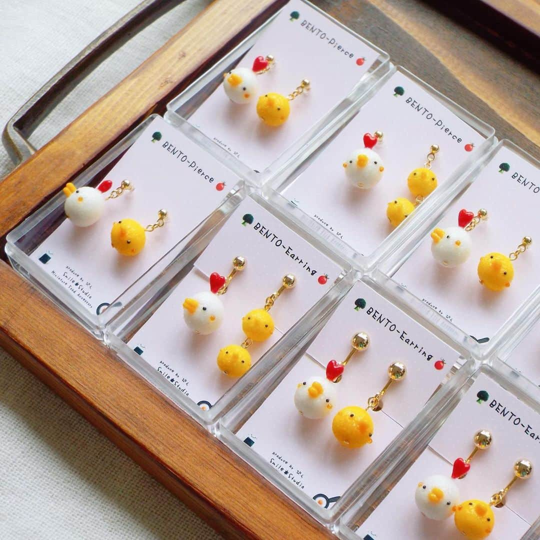 すまいる*工房(ぴん) のインスタグラム：「* お弁当シリーズからの おむすび🍙と🐔🐤のおむすび そしてプチトマト🍅のピアスとイヤリングとブローチ * ケースにセットしました🤲🏻 こちらも販売します😊 * 出店ブース番号は アクセサリーブースのA039ですꕤ︎︎·͜· ︎︎ * こちらのイベントで販売します ↓↓↓ minneハンドメイドマーケット 9月16日(土)、17日(日)、18日(祝・月) 東京ビックサイト東7ホール ブース番号 A039 3日間出店します🐾ᵕ̈ *  #minneハンドメイドマーケット  #ミニチュアフードアクセサリー  #ミニチュアフード #miniaturefood  #minne #minneのハンドメイドマーケット #ハンドメイドアクセサリー #おむすび #🍙 #おにぎり #プチトマト #お弁当」