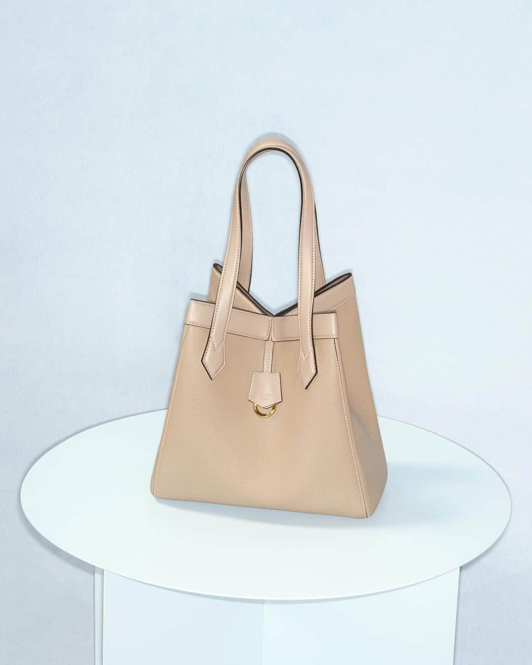 のインスタグラム：「Folded into a bucket silhouette, the #FendiOrigami tote shows its shapeshifting ability.  The bag is now available in a sophisticated palette of colours in boutiques and at Fendi.com.  Artistic Director of Couture and Womenswear: @mrkimjones  Artistic Director of Accessories and Menswear: @silviaventurinifendi  Artistic Director of Jewellery: @delfinadelettrez   Photography: @johnnydufort   Styling: @themelanieward Hair: @benjaminmullerhair  Makeup: @lynseyalexander   Casting: @shelleydurkancasting  Set Design: @maxbellhouse  Model: Xiru Yang」