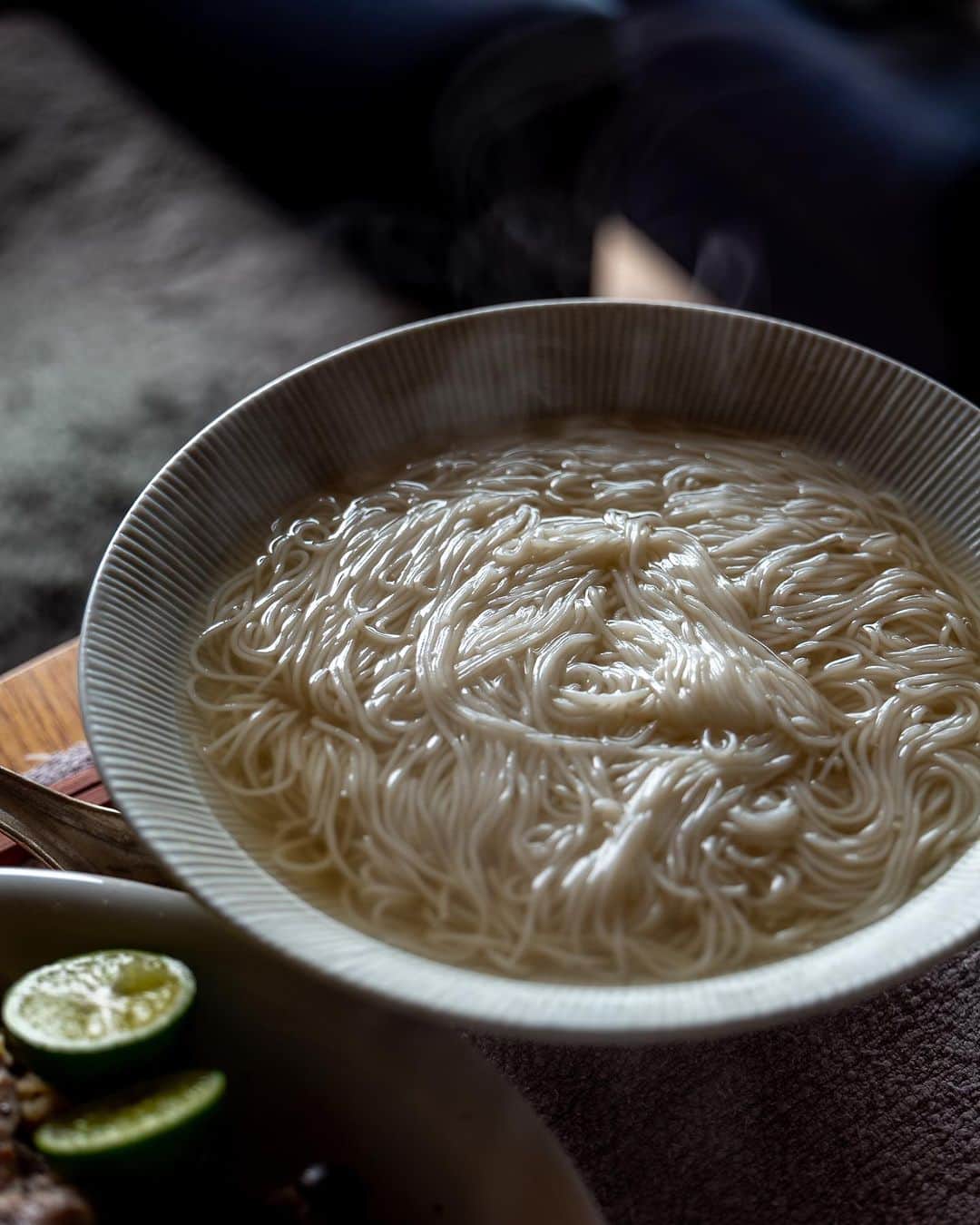 のインスタグラム：「煮麺。  Today I have a dinner party at 3:00 p.m. I am not sure if it is dinner or lunch, but it is a restaurant that has a waiting list of several years for reservations, and this was the only time available for a private party. I had not eaten breakfast recently, but it was hard to hold off until 3:00 p.m., so I made boiled noodles in the morning. I made noodle soup by mixing chicken stock, bonito stock, and dried sardines. I took the chicken out of the broth, chopped it up, and added sesame oil, salt, and pepper. Mushrooms and vegetables were boiled and garnished with a generous amount of squeezed sudachi juice.  #leica_photos #leicaphoto #leicaphotography #leicasl #leicasl601 #foodphotography #foodphotographyandstyling」