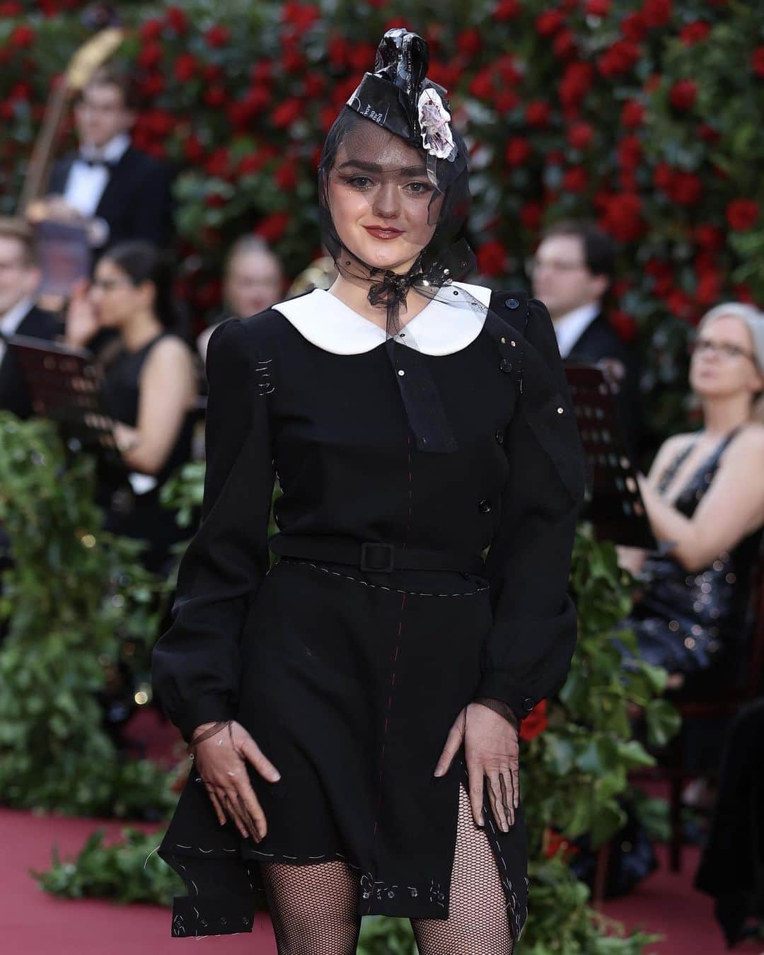 Maison Margielaのインスタグラム：「On the occasion of Vogue World: London, @Maisie_Williams wore look 35 from Maison Margiela designed by @JGalliano Co-Ed 2023 collection, a black wool romper with a white cotton padded col claudine worn over a black latex bra with matching knickers, black fishnet tights, black bin liner and tulle hat, and silver lamé lurex pumps.」