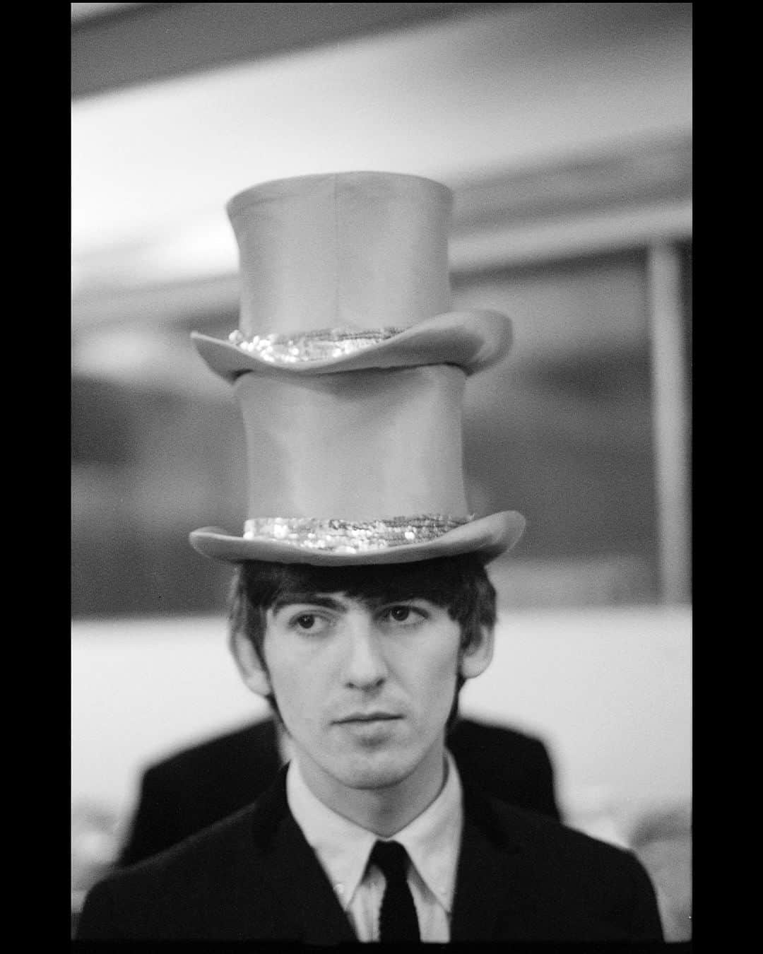 ポール・マッカートニーのインスタグラム：「George with two hats. London  "It’s what makes life great: when you look back and you think, ‘Wow, we did that. We did all of that, and we’re just kids from Liverpool." - Paul  🎟️ Paul McCartney Photographs 1963–64: #EyesOfTheStorm @nationalportraitgallery in London until October 1st. Tickets for the last remaining weeks are available now via the link in bio.」