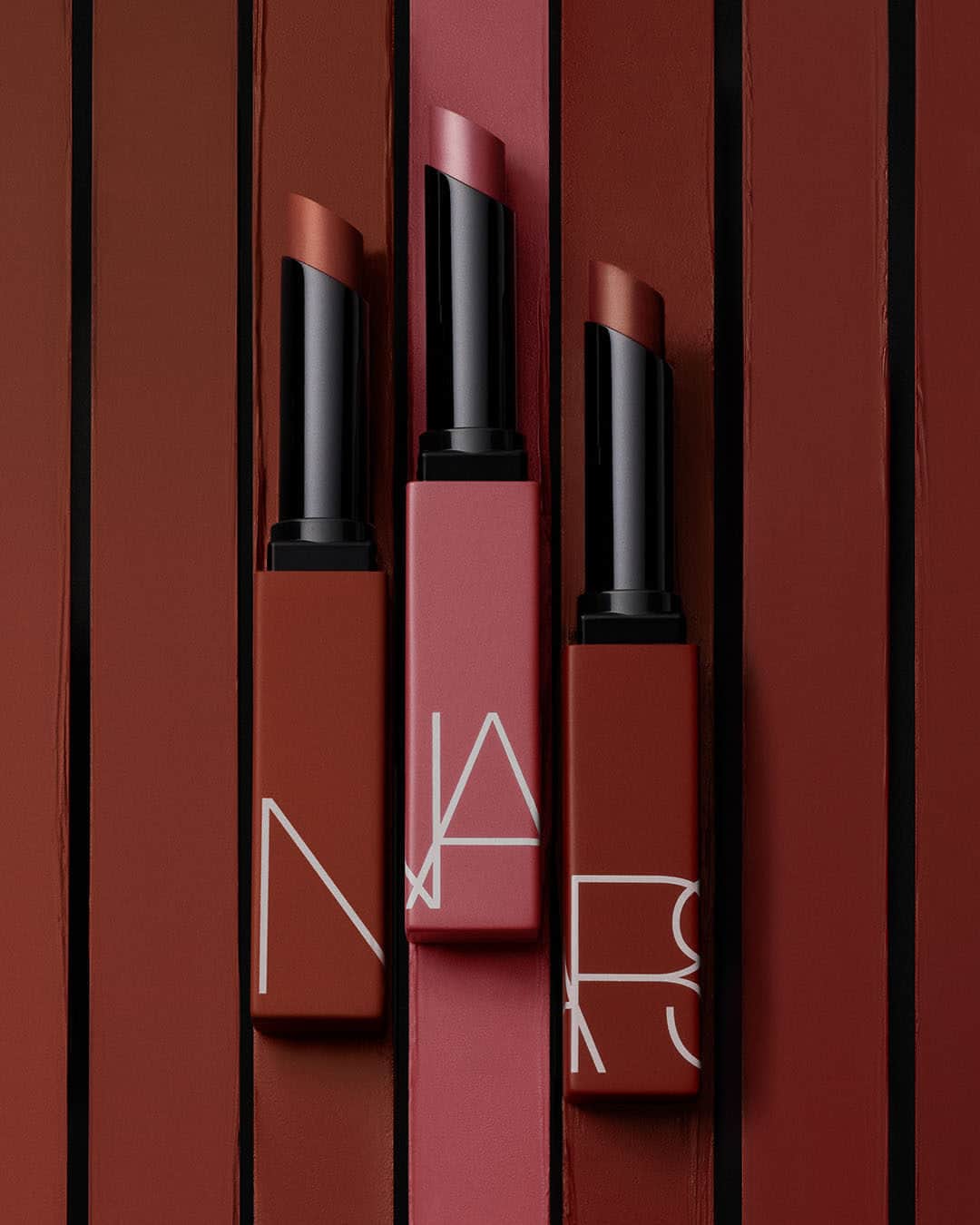 NARSのインスタグラム：「Enter autumn in style. Find your fall-favorite shade of Powermatte Lipstick, featuring chestnut rose American Woman, soft brown pink No Angel, and brick red Mogador.」