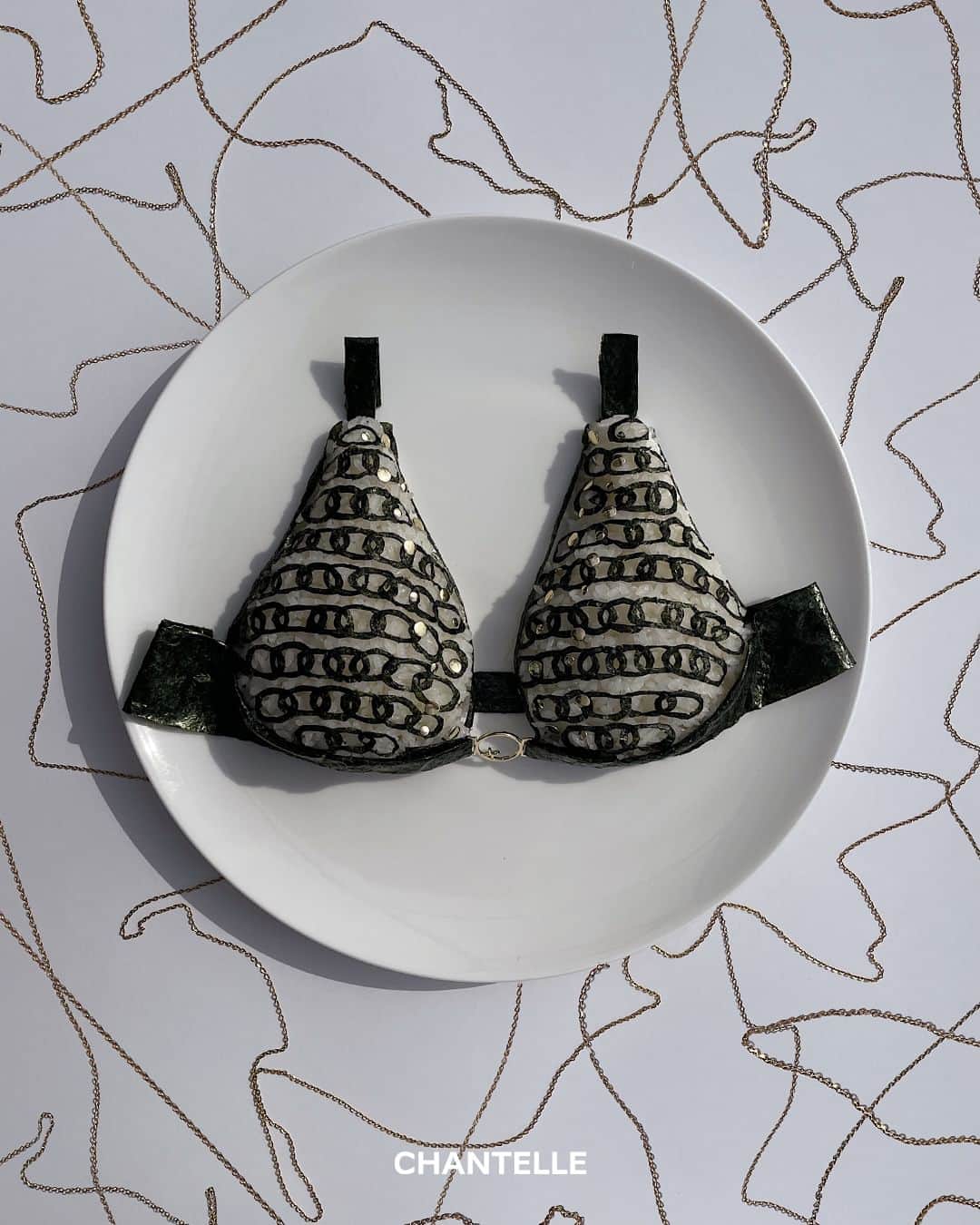 のインスタグラム：「"Golden Seaweed Glamour" by @dimda_   We asked Japanese artist and culinary genius @dimda_  to revisit some of our favorite items.  For this third and final post, Daisuke put a twist on our upcoming new @chantelle_______x line : "MetallX".  Shown above: rice and seaweed delight inspired by #FW23 "MetallX" Plunge underwired bra  #GoodEnoughToEat #Chantelle #ChantelleMetallx」