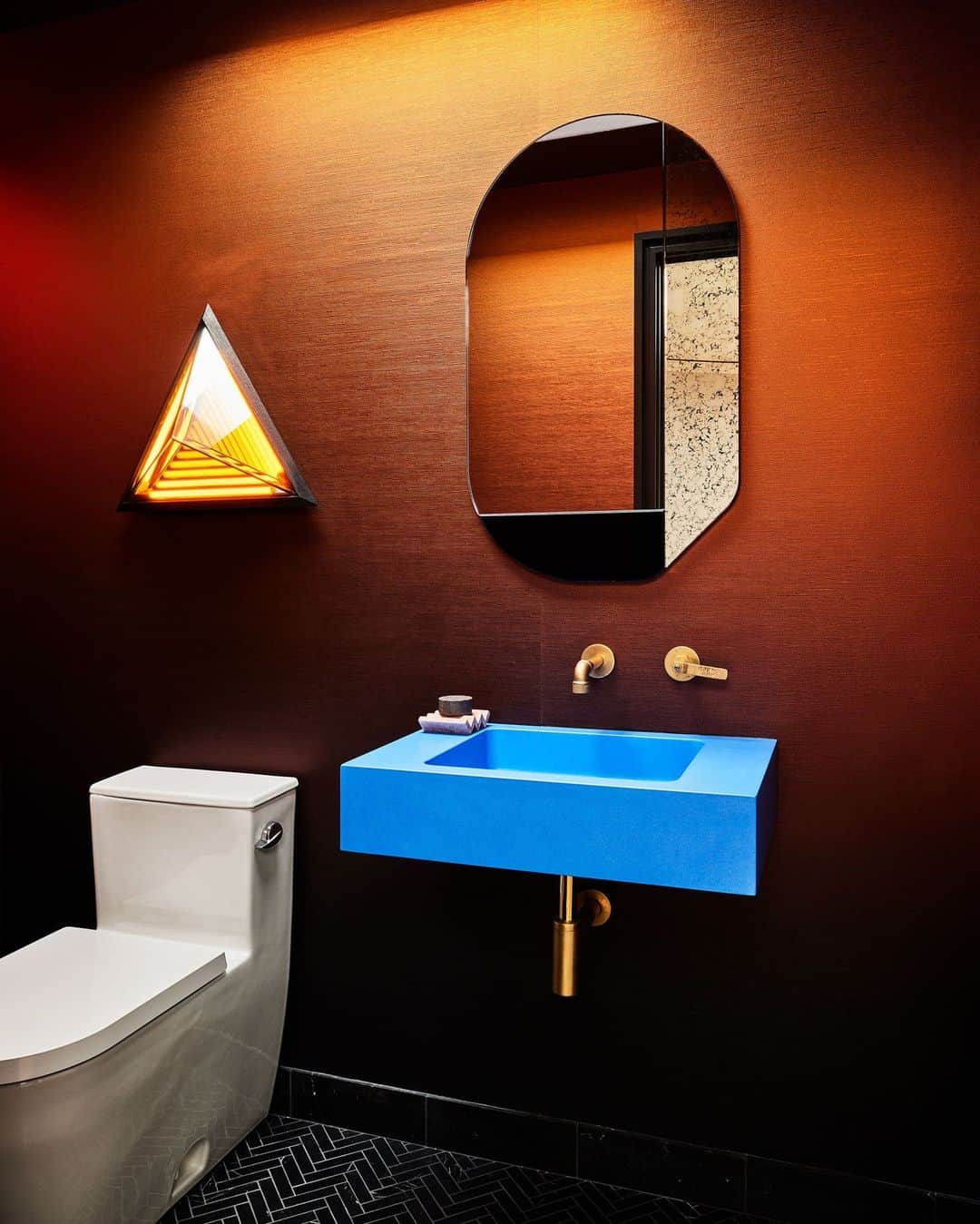 のインスタグラム：「This space certainly puts the “pow” in “powder room.” The vibrant half-bath, located in a San Francisco Edwardian designed by local firm  Homework (@homeworkdesignshop), practically radiates energy with its Yves Klein–blue custom sink, Frank Stella–inspired sconce by Rosie Li, and burnt-orange metallic wallpaper from Calico. “It was like a trust fall; she just kind of fell into our arms,” says firm cofounder Susan Work of working with the client. “Every room just evolved [to be] deeper, punchier, more saturated, more fun, more artful.”  Click the link in bio to discover the rest of this sophisticated family residences. Written by @anna_fixsen. Photographed by @nicole_franzen.」