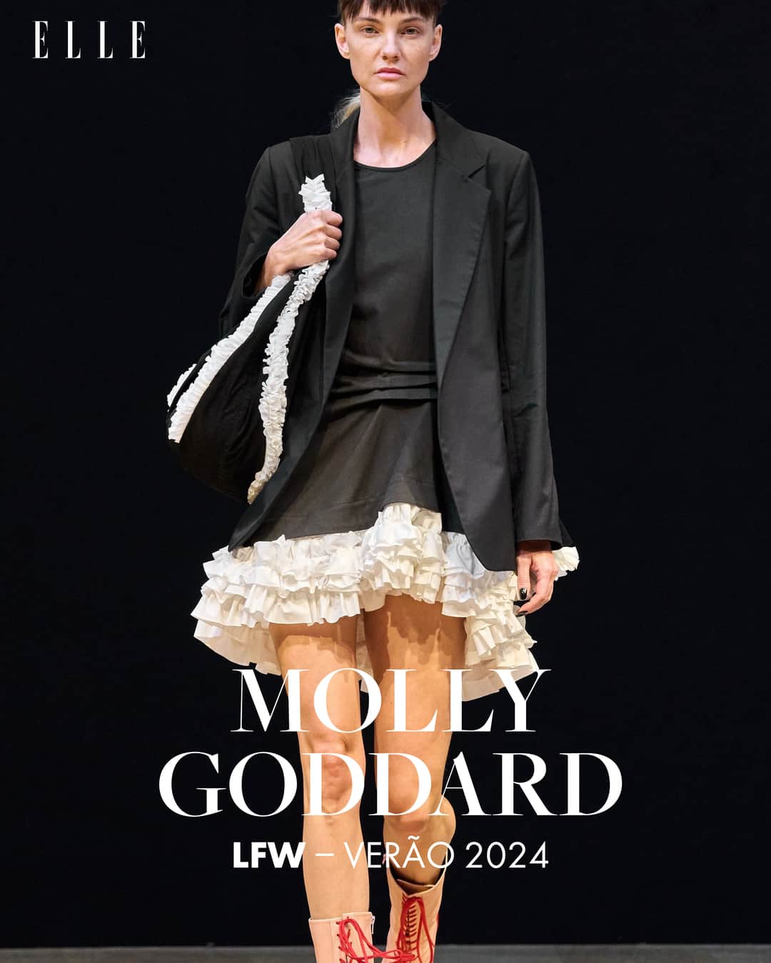 ELLE Brasilのインスタグラム：「Ao som de "I’ll Send You a Witch", @mollygoddard colocou as suas modelos para cruzarem a casa de leilões Christie's, usando uma faixa amarrada na cabeça, durante a edição de verão 2024 da semana de moda de Londres. E, assim como as referências do desfile, que passeiam do século 19 aos dias de hoje, a silhueta é igualmente diversa e vai dos micros aos longos. Mas, no geral, o comprimento das saias deixa os pés à mostra, ou melhor, a bota com cadarço ou a sapatilha de amarrar à vista.   Esse vela e revela está presente nos vincos e pregas, que levantam o tecido e deixam aparecer uma parte da anágua, ou o que quer que esteja ali embaixo. Provocação semelhante rola também no styling e na construção de algumas peças, como os corsets de costas abertas ou os vestidos que já têm a parte de trás não fechada.   Apesar de todos esses artifícios, a sensualidade construída por Goddard não é óbvia. Do mesmo jeito, seus famosos vestidos volumosos, em tons pastel e cheios de frufrus, não são imagens literais de ultra feminilidade. Em determinado momento, a sua apresentação nesta semana de moda de Londres caminha para uma imagem doméstica que embaralha ainda mais o olhar. Goddard recupera uma memória de casa, com vestidos com jeito de avental ou roupas acolchoadas parecendo edredom.   Algumas modelos surgem como quem faz parte da mobília, uma continuidade da cortina ou do papel de parede. E fica no ar se a apropriação é uma ressignificação ou se reforça a ideia da mulher que é tão parte da casa que uma coisa não se desvincula da outra.   Uma pena que isso esteja mal resolvido principalmente nas modelos que não são magras. Se essas são as bruxas de Molly Goddard, como sugere a trilha, a sociedade já vem dizendo o mesmo há séculos e parece faltar uma ironia, deboche ou desvio do esperado. (via @gabrielhmonteiro)」