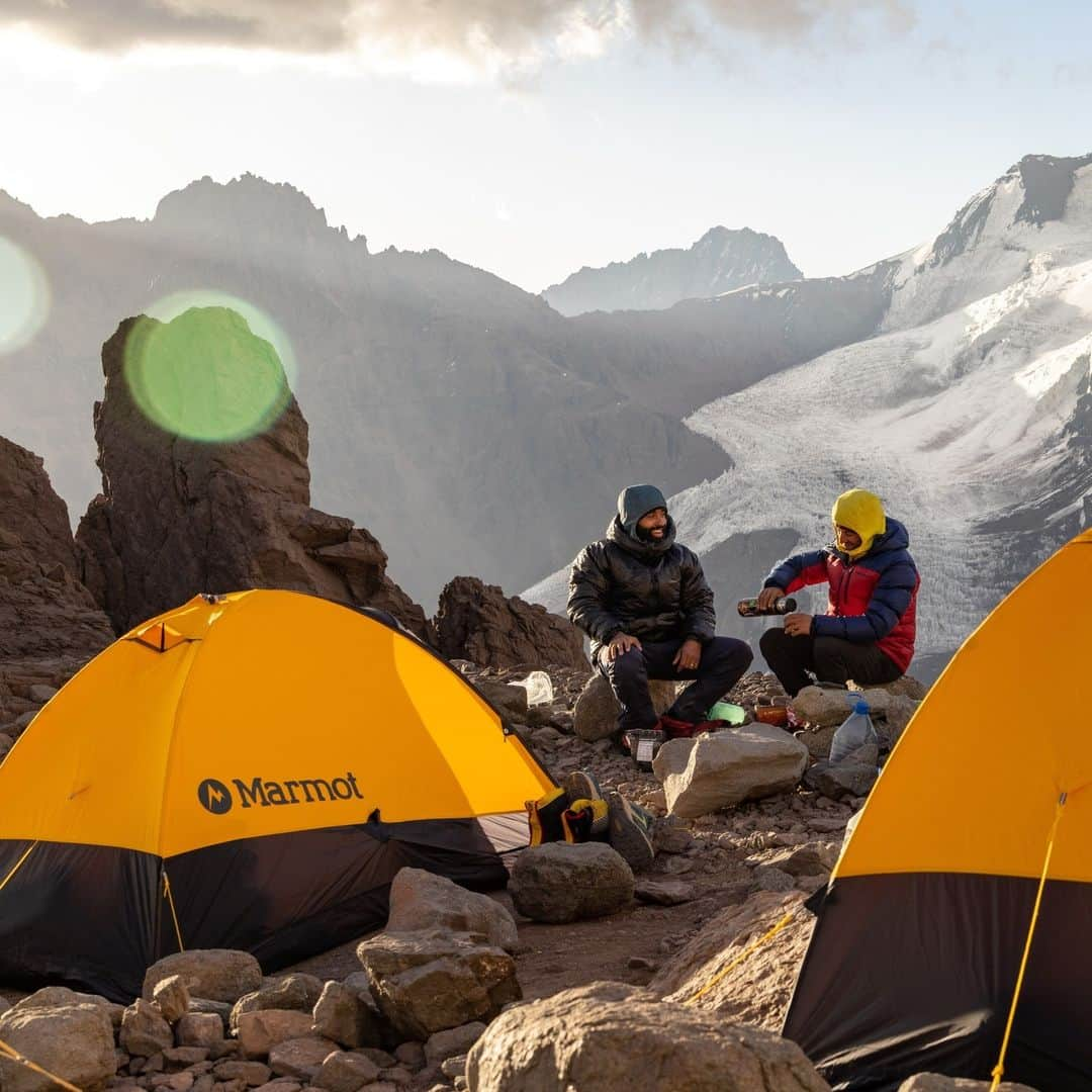 マーモットのインスタグラム：「Max Djenohan (@nomadikmax) and Bruno Pavone (@brunopavoneguide) at Camp 1, 16,568ft.  Bruno and Max pour hot water into the Yerba Mate, an Argentine tea-like custom and watch the sunset.  Aconcagua Provincial Park. January 2023.  Photo: @jsack_foto  #Marmot」