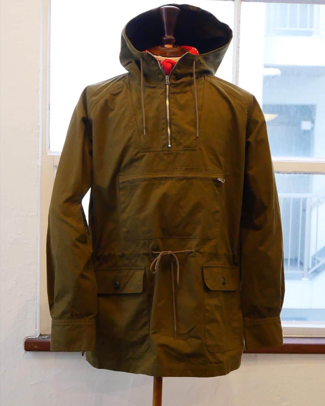 サウンドマンのインスタグラム：「Soundman '23AW Collection Item. "Lex" アノラック、スモックパーカーとか言われますが、いわゆる被りのフードアウター。ここ数年でかなり浸透してきた気がします。 確かに前が開いた方が着易いのですが、胸につく大きなポケットやら胸元のフードの溜まり具合、ウエスト絞って着た時の全体の収まりっていうのかな、これはこのディティールでしか出せません。 また冬の寒い時期に中間アウターとしても使えます。 弊社在庫このオリーブグリーンは38サイズのみとなりましたが、ピンときた方は是非！ ＊もう一色のブリックは38/40まだございます。  #soundman #サウンドマン #2023aw #heritagestyle #vintagestyle  #heritagemenswear  #横浜 #山下公園 #yokohama #anorak」