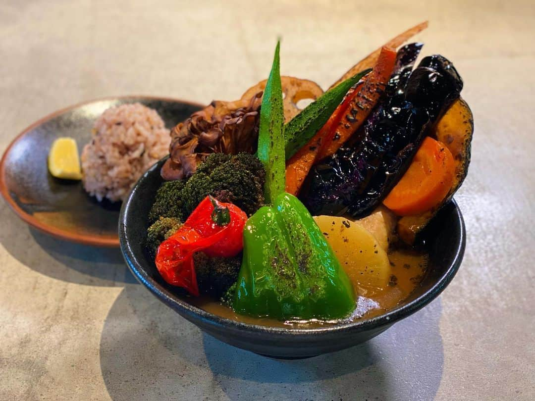 南雲穂波のインスタグラム：「野菜もりもりカレー！🍛 今月の絶景めしは"ウマ辛絶景"の世界でした🌏  一店目に登場したのは… SOUP CURRY ISHIBA 金山駅の近くにある大人気のスープカレー専門店. 肉が骨から自然にほぐれるほど柔らかく煮込まれたチキンスープカレーなどが楽しめます.  🍽️チキンスープカレー+野菜増しトッピング スープが見えないほどに色とりどりの野菜が天高く盛られたスープカレー！増しすぎ〜！ その姿はまるで山形県と福島県にまたがる#吾妻連峰 の麓に広がる#天狗の庭 のよう🍁  素揚げされた新鮮野菜はとっても甘くて、国産のチキンレッグはトロトロに仕上がっていました. コラーゲンたっぷりな鶏ガラベースに、香味野菜、果物、昆布、13種類のスパイスをブレンドしたスープが素材の美味しさを引き立てます✨  #soupcurryishiba #スープカレーイシバ #ドデスカ！ #絶景めし #メーテレアナウンサー #南雲穂波」