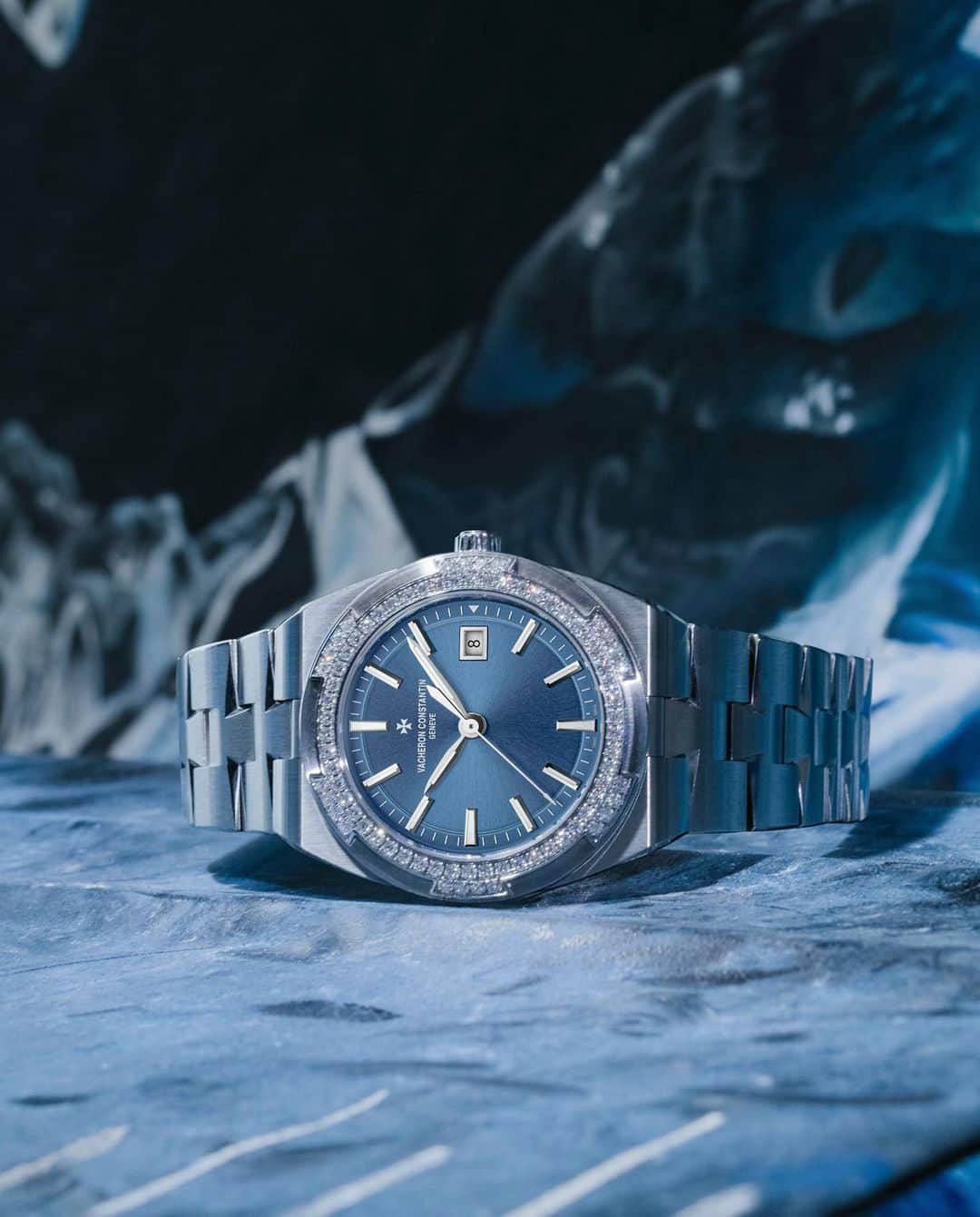 のインスタグラム：「Blue burst 🧊  On the wrist - @zarialynn wears the Overseas 33 mm, an elegant timepiece with a sporty character. The six-sided bezels adorned with “brilliant”-cut diamonds light up the path of the hands and the date appearing at 3 o’clock.  American artist Zaria Forman has joined Vacheron Constantin's "One of Not Many" talent circle alongside Benjamin Clementine, Ora Ito, Cory Richards and Yiqing Yin. She is becoming the new face of the Overseas collection, for which the advertising campaign was produced in Iceland.   During the shoot, Zaria Forman once again collected her own images and memories, constituting the raw material for a series of drawings, video work, and sculpture, entitled Fellsfjara, Iceland, of which work no. 3 was created for Vacheron Constantin.  #VacheronConstantin #OneOfNotMany #vacheron #thehourlounge #watches #watch #watchesofinstagram #vcoverseas」