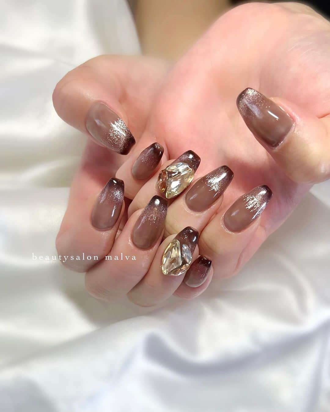 nailsalon malva（ネイルサロンマルヴァ）のインスタグラム：「【ベーシックプラス138】でご予約可能✨ ⁡ 秋に人気なブラウンカラー🤎 透けたブラウンベースに、 先端のマグネットは焦げ茶色でかわいいんです🥰 ⁡ 大ぶりビジューもポイントになって目立ちますよ✨ ⁡ ↪︎ ネイルのケアと保証期間 ⁡ malvaのネイルはドライケア、カットスタイルも込みです。 保証期間は約4週間となります（※ご新規様は3週間となります）。 ⁡ ＿＿＿＿＿＿＿＿＿＿＿＿＿ ⁡ ⁡ 𝐛𝐞𝐚𝐮𝐭𝐲𝐬𝐚𝐥𝐨𝐧 𝐦𝐚𝐥𝐯𝐚⠀ 📍明治神宮前駅｜原宿駅　徒歩𝟑分 ⠀ 💬ご予約やお問い合わせ 𝐋𝐈𝐍𝐄から承っております @ 𝐦𝐚𝐥𝐯𝐚 ⁡ お気軽にご連絡ください♡ ⁡ ⁡ ＿＿＿＿＿＿＿＿＿＿＿＿＿＿ ⁡ ▸ジェルネイル｜スカルプ｜ネイルケア ▸まつげカール｜まつげエクステ｜ワンホンエクステ ▸ハーブよもぎ蒸し ▸ワックス脱毛 ⁡ \ アシスタント募集中💁‍♀️ / ⁡ ▸リモート可オンラインの画像動画制作アシスタント ▸サロンワーク全般アシスタント ⁡ ⁡ #秋ネイル2023 #ブラウンネイル #マグネットフレンチネイル  #マグネットブラウンネイル #malva #malvaネイル  #ビジューネイル #ロングネイル  #大人きれいめネイル #原宿ネイル #秋ネイル  #表参道ネイル #東京ネイルサロン　#明治神宮前ネイル #新宿ネイル #千駄ヶ谷ネイル  #harajukunails #tokyonails #tokyonailsalon ⁡」